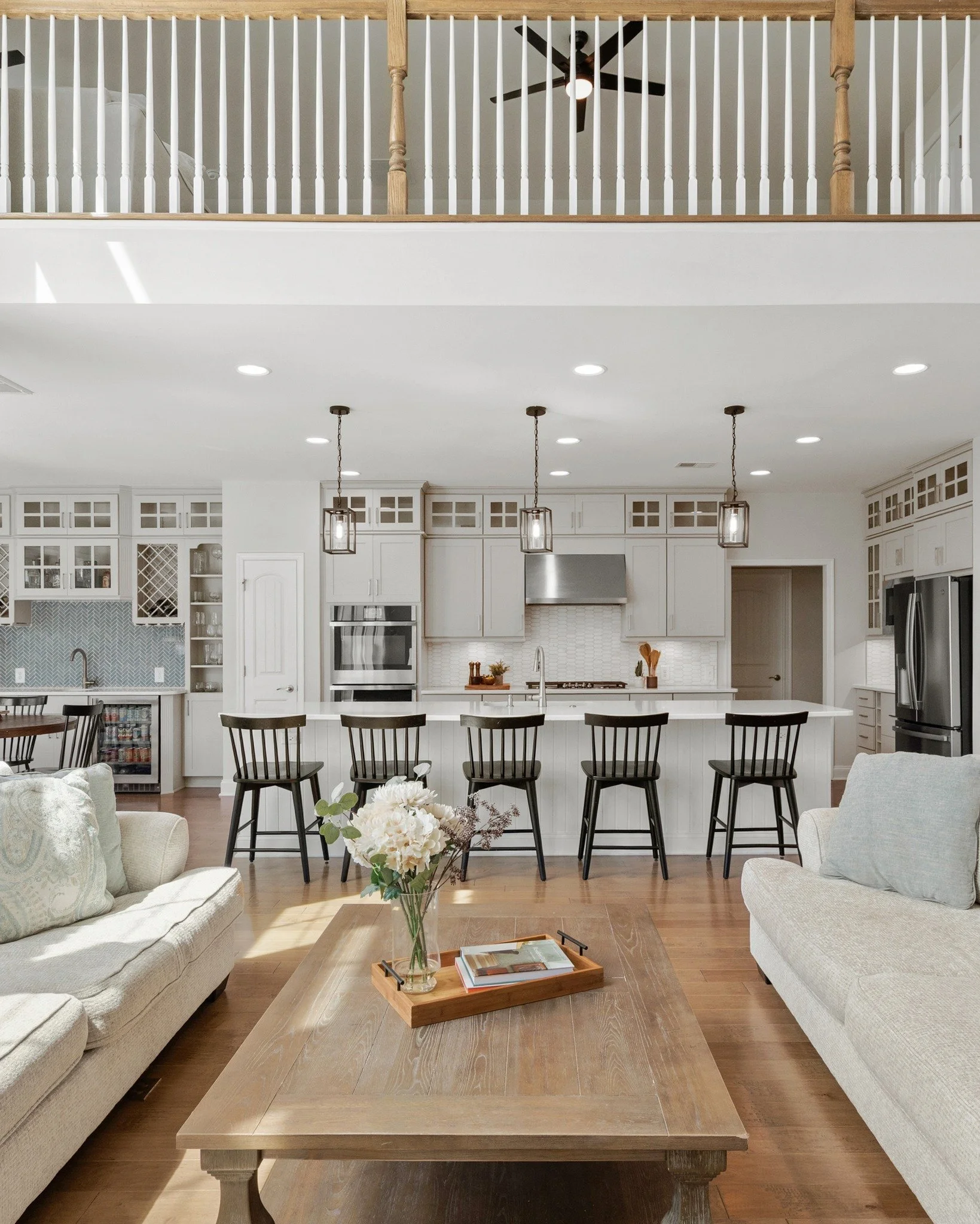 Standing by the fireplace, your eye carries straight through the space to the kitchen&mdash;landing softly on that single chair at the island. It&rsquo;s open in a way that feels effortless, not overwhelming.
And the light&hellip; pouring in from tha