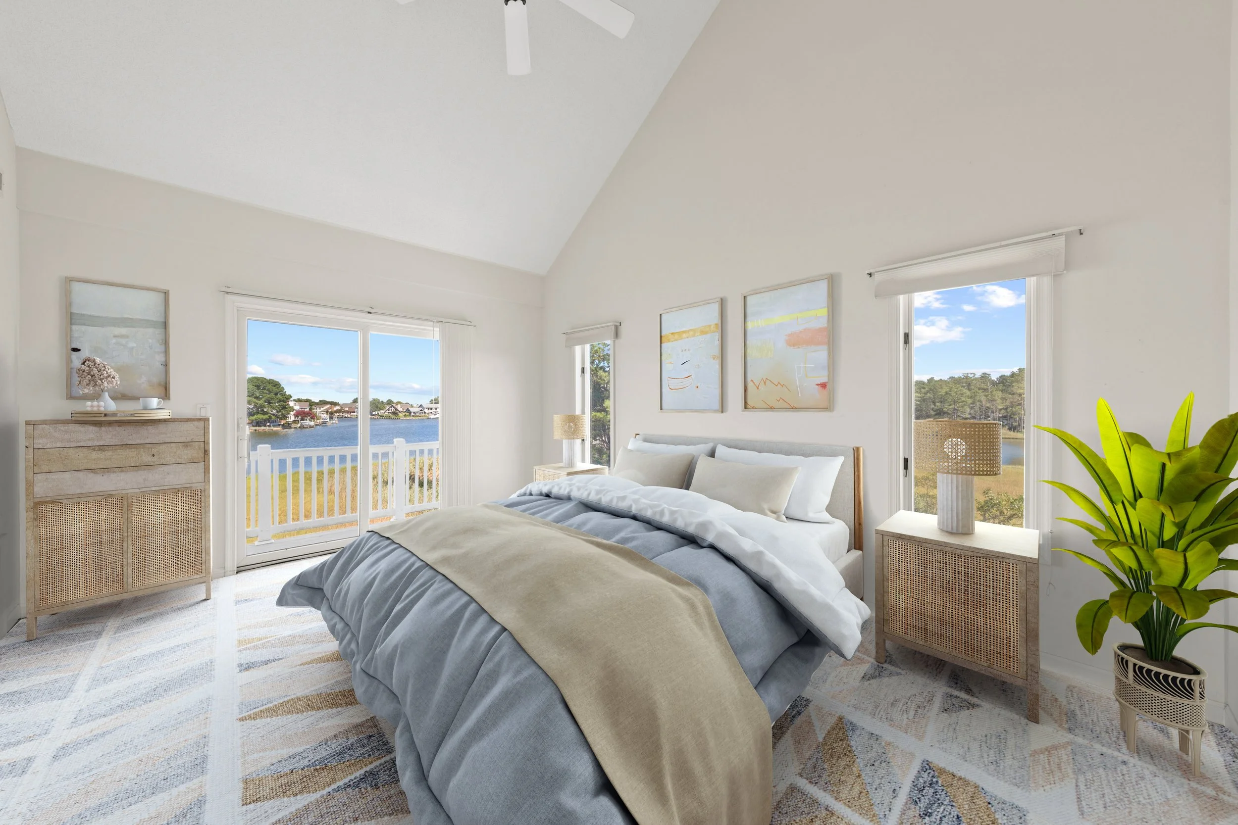 Bright bedroom with large windows overlooking a water view, decorated in neutral tones with a bed, nightstands, artwork, and a potted plant.