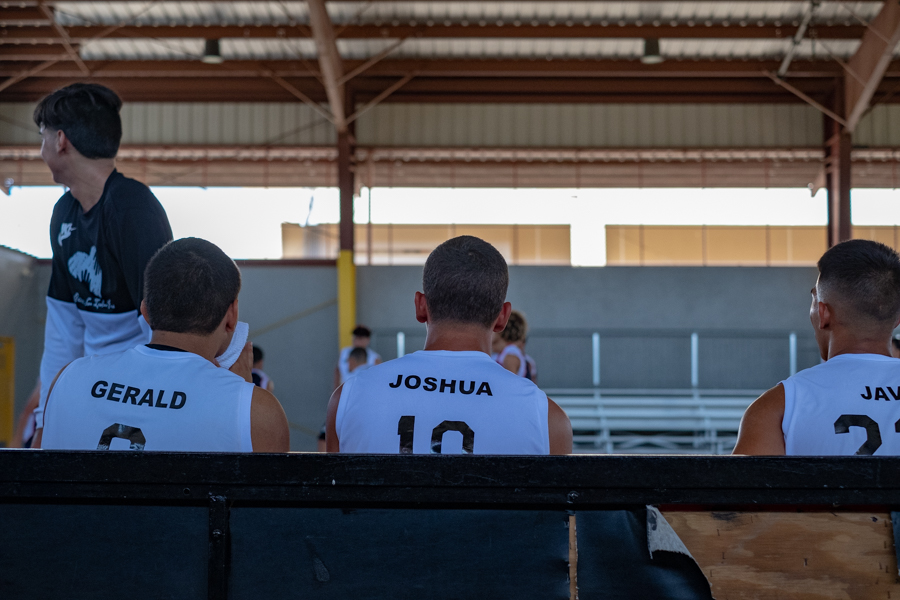 Basketball team watches the action on the court
