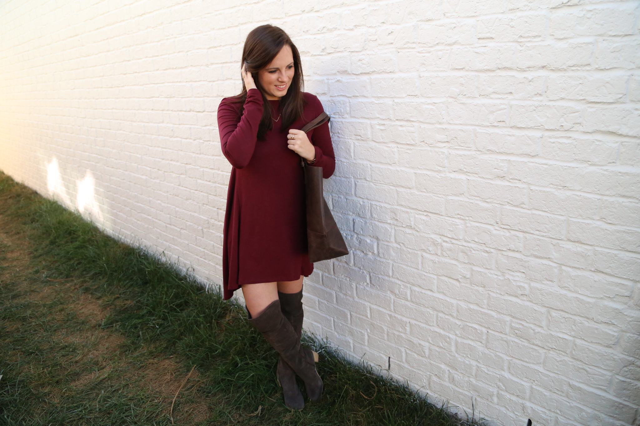 PHOTO: JESSICA VALIYI Esther Dress in Maroon: Grace's Shop Dark Mamuye Tote: Grace's Shop Make A Wishbone Necklace: Grace's Shop Muse OTK Boots: e.Allen Boutique