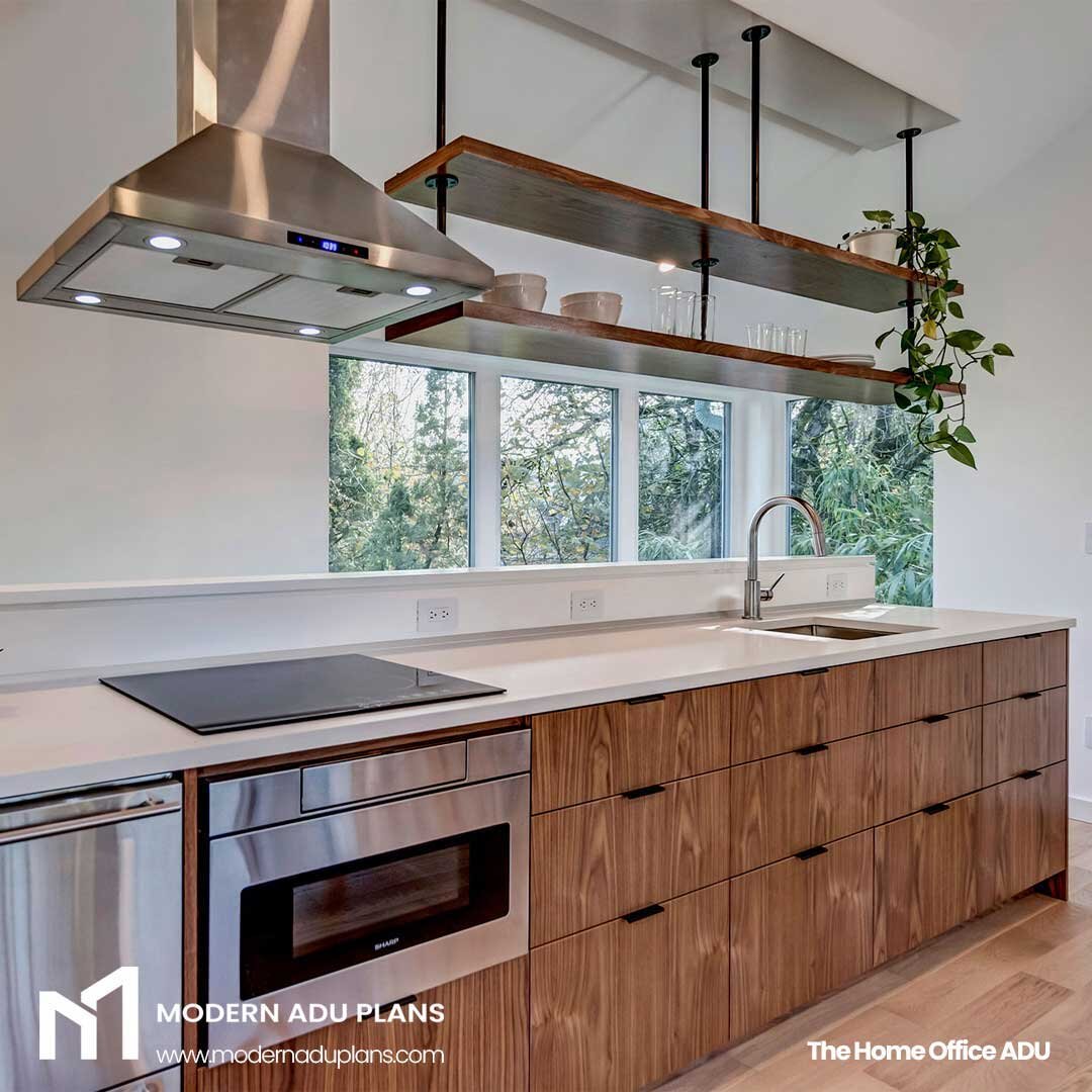 This compact kitchen features an under counter refrigerator (bottom left of the photo), induction cooktop, oven/microwave combo, and has plenty of storage between the cabinetry and the open shelves above. 

But it also does double duty as the guard r