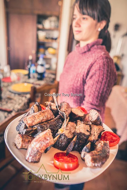 Serving a plate of BBQ meat and sausage. La Pampa, Argentina ©tonybynum.com