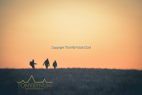 Hunters crossing the open prairie grasslands at first light. La Pampa, Argentina ©tonybynum.com