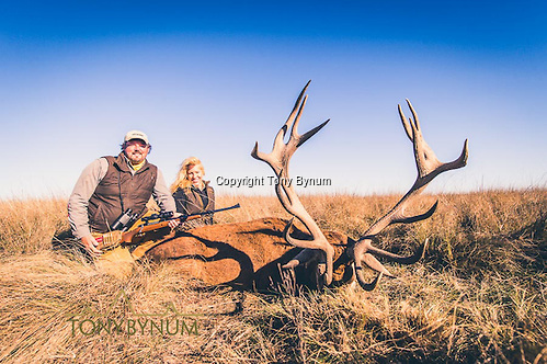 Husband and wife hunter with a trophy, free range, stag from Los Molles ranch. La Pampa, Argentina ©tonybynum.com