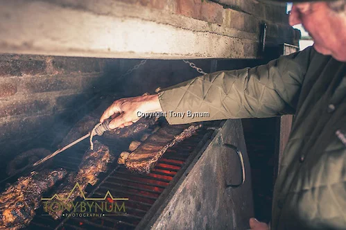 The cook checks the meat for doneness. La Pampa, Argentina ©tonybynum.com