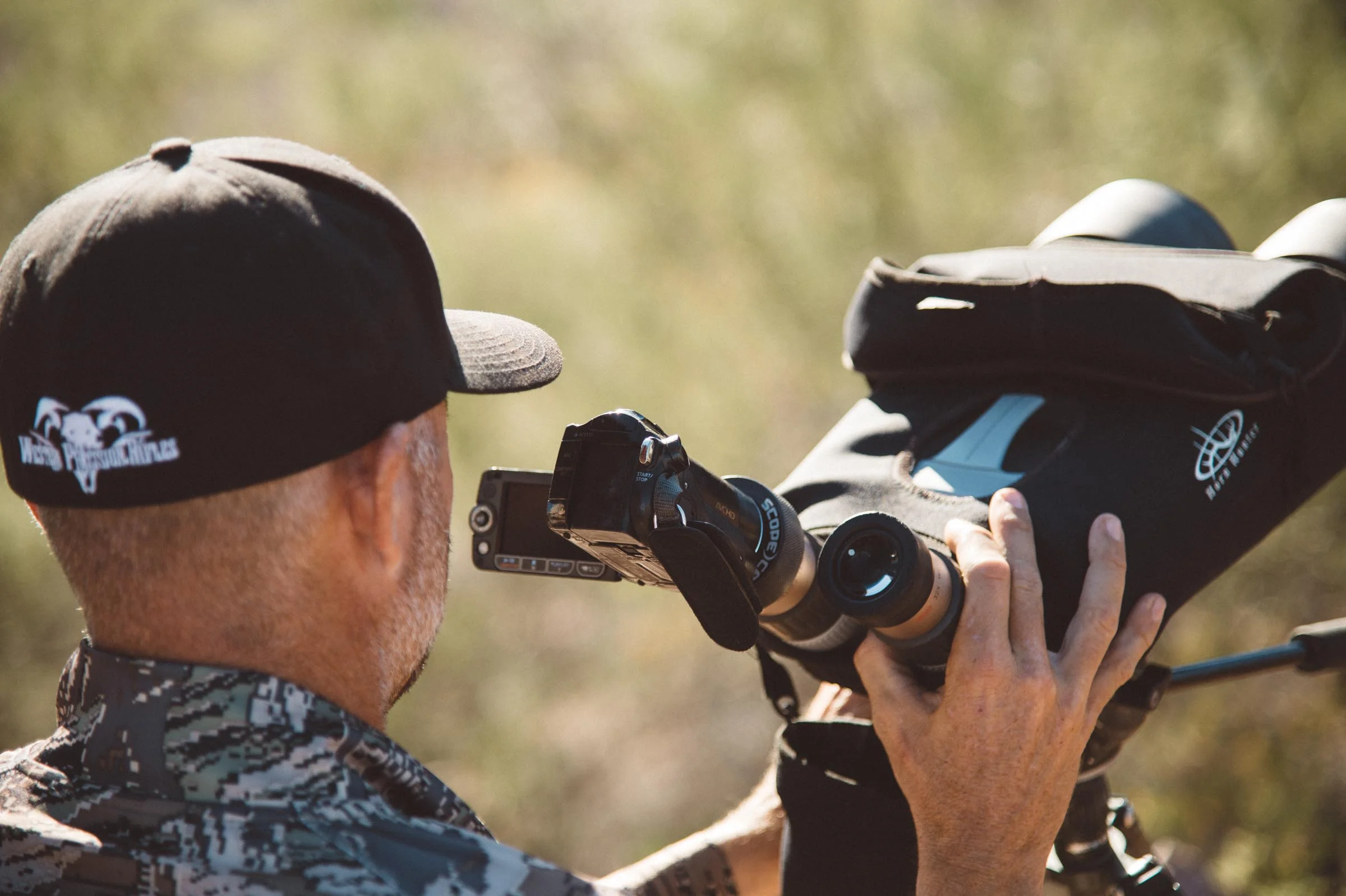 Hunter filming with a digital video camera though a pair of Kowa Optics. © Tony Bynum