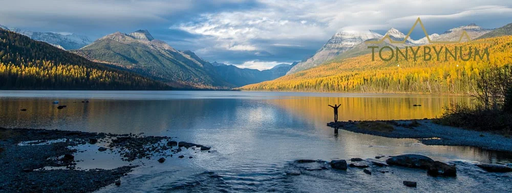 Fall in Glacier National Park - Stacy Dolderer stands on the edge of a lake in beautiful Glacier National Park. © Tony Bynum 