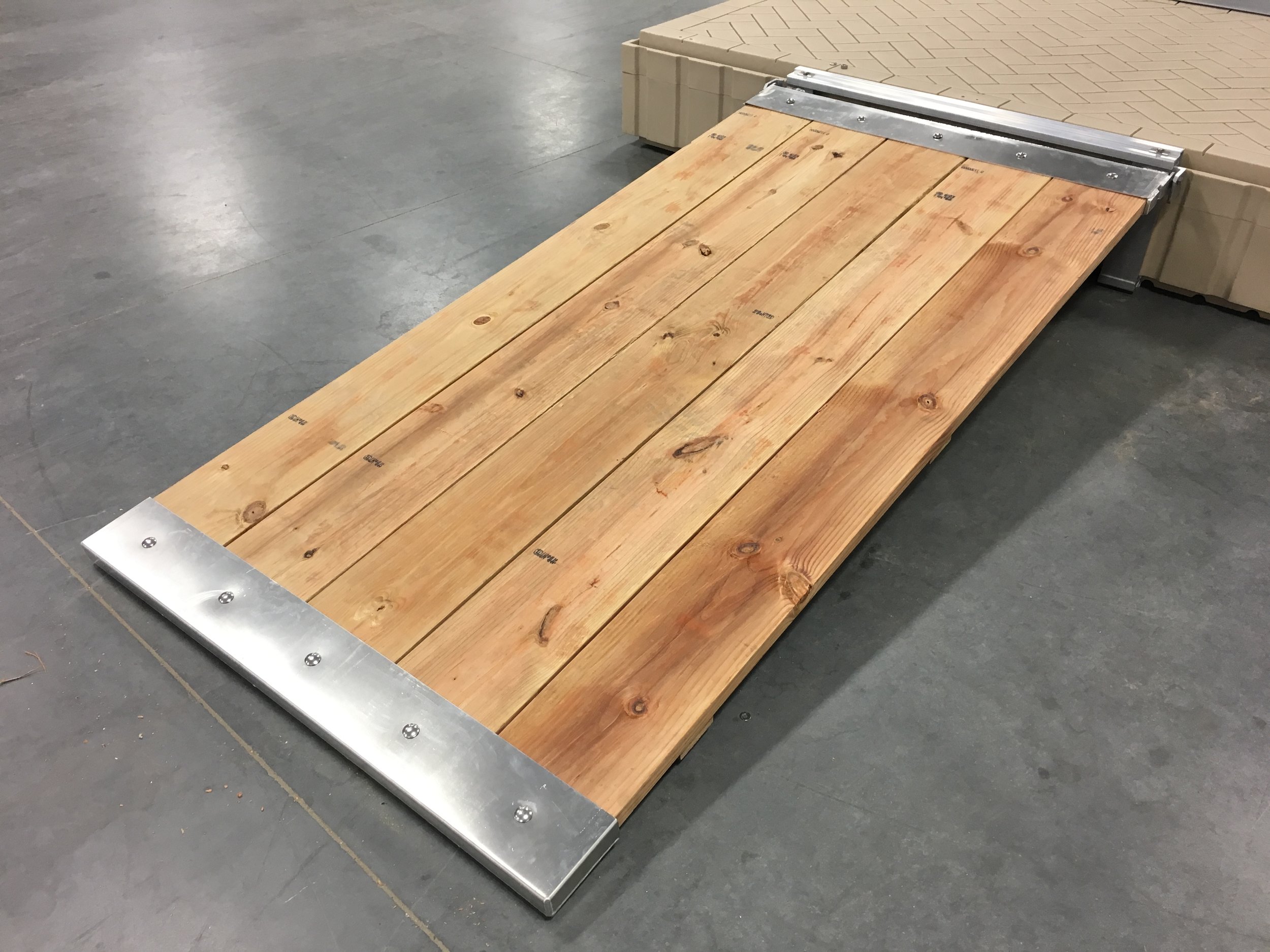 This walkway kit is designed to let the customer supply his own 2 x 10 treated boards and cut them the exact length he needs his walkway to be to fit to a new dock or replace an existing worn or weathered walkway. Walkway will measure 4' wide and can be any length you cut your 2" x 10" boards. Requires ( 5 ) 2" x 10" treated wood planks to give you a 4' wide walkway. ( Supplied by customer ) The walkway above is shown connected to a Shoremaster poly dock. This is the poly we handle, so we obviously designed the kit to bolt to the brackets that are part of the Shoremaster poly dock system that you can purchase when you buy your poly float. As shown in the pictures below, you will receive all the aluminum parts and hardware to build the walkway shown above, less the wood. ( This kit does not include any lumber ) This walkway, can be adapted to almost any dock you have, wood, poly or aluminum. It really is a very universal kit made to save you time and money and give you years of performance. This kit includes: ( 1 ) Aluminum welded end cap. ( shore end, shown next to bolts below ) ( 1 ) Aluminum 3" x 3" angle dock mount with pivot point mounts. ( shown on top of poly float ) With this bracket you can lag it into almost any style of dock you may have. You will need to drill holes in this bracket to mount it to your dock and get the bolts that fit your needs. ( You will not need this part if you are mounting it to a Shoremaster float that you purchased the mounting brackets that are made to bolt to the float from Hotwoods, or any Shoremaster dealer.) ( 1 ) Aluminum welded connection cap with pivot points to bolt to your dock bracket. ( on floor next to poly float ) ( 2 ) stainless steel bolts with nuts and washers. ( pivot point connectors ) ( 10 ) stainless steel bolts with nuts and washers to bolt your caps on your wood. Kit does not include any lumber ( this will be supplied by the customer ) UPS Shippable Standard Wooden Walkway Kit ( less wood ) $495.00 plus shipping