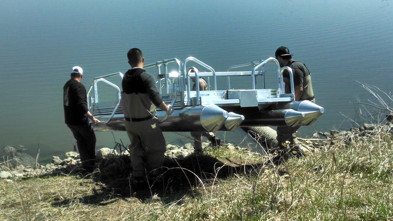 With the weight of the Fish N Sport at 405 pounds it is very easy for 4 men to carry it to hard to get to spots like this lake in Colorado that did not have a ramp to unload it from the trailer. Also the side rescue rails are a great aid to the men carrying the boat as you see in the photo. These rails can be added to any Hotwoods pontoon boat we manufacture.