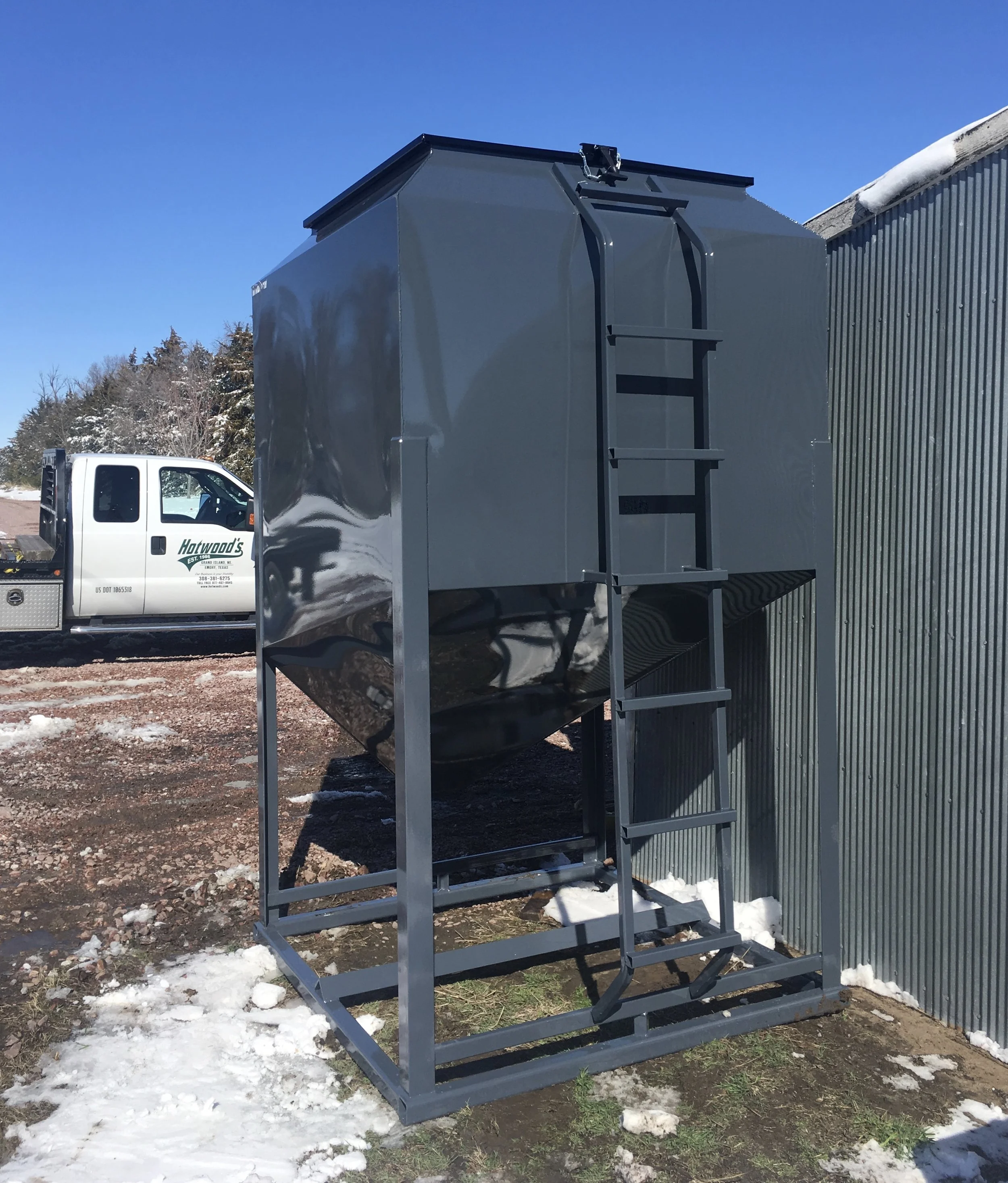 As shown in above photo, the 6,000 Lb. bin comes standard with the ladder welded to the frame work on the bottom and the bin on the top. This assures your safety when climbing up to the top of the bin.