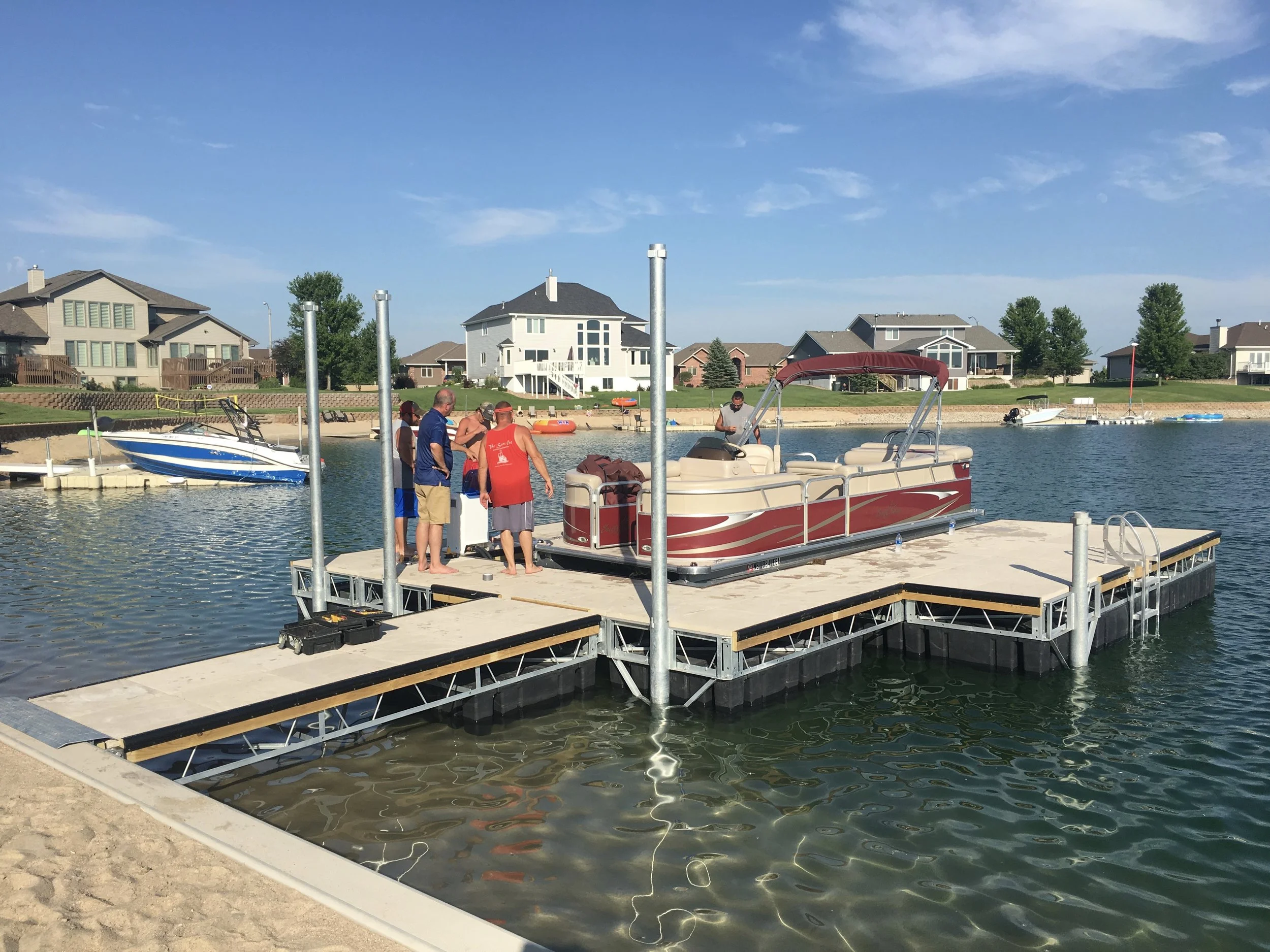 Hotwood’s installation crew working with a local customer to get his new boat lift adjusted and make sure everything is working properly. Once the 3 galvanized poles are lowered and set on the front, this concrete dock and lift installation will be complete. This is what we would call the ultimate set up. ( Before this dock was installed, the customers old used dock was removed by this same crew. )