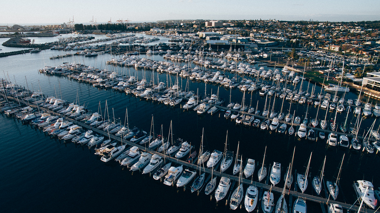 Aerial view of the Fremantle Shipwrights yard at the Fremantle Sailing Club, boats on hard standing beside the undercover sheds