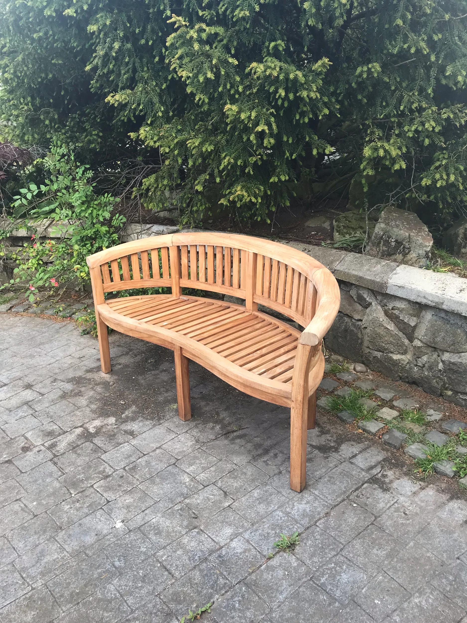 A solid teak bowed complete garden seat. £250. Free delivery locally