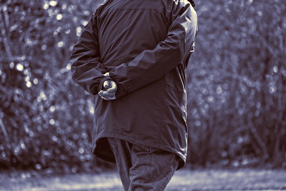 The back side of a man walking away in a light jacket and jeans. His arms are crossed behind his back as he walks. What does this say in reference to Lecoq gesture?