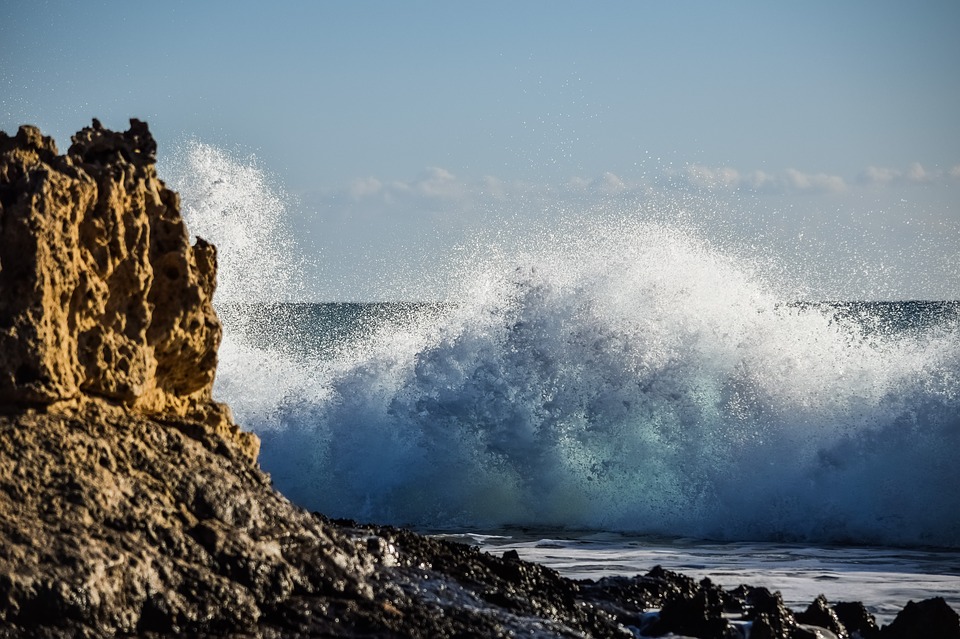 A big wave hitting a rocky shore.
