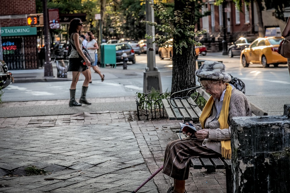 A street in New York City. An old woman sits on a bench reading, some young women walk. It is a warm summers day. Start walking down the street and practice this Alexander Technique a, Acting, and Presence Exercise.