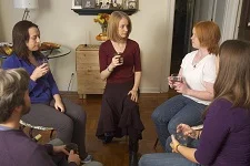 Dana Calvey, Alexander Technique Teacher and Guest Instructor at AT Motion Center for Actors kneels on the ground with a group of students going over Alexander Technique principles.
