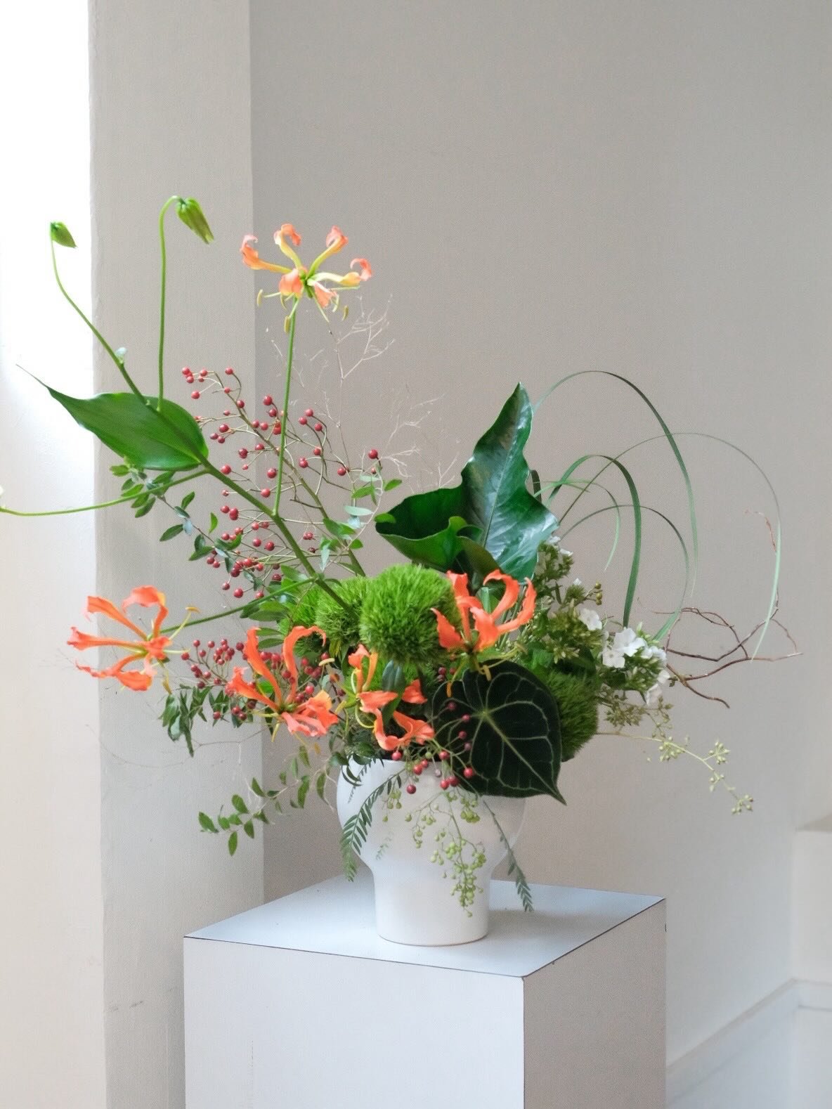 Where motion meets quiet &mdash; gloriosas unfurling from a grounded, sculptural base.

A Japanese-inspired arrangement that settles into calm even as its lines reach and arc.