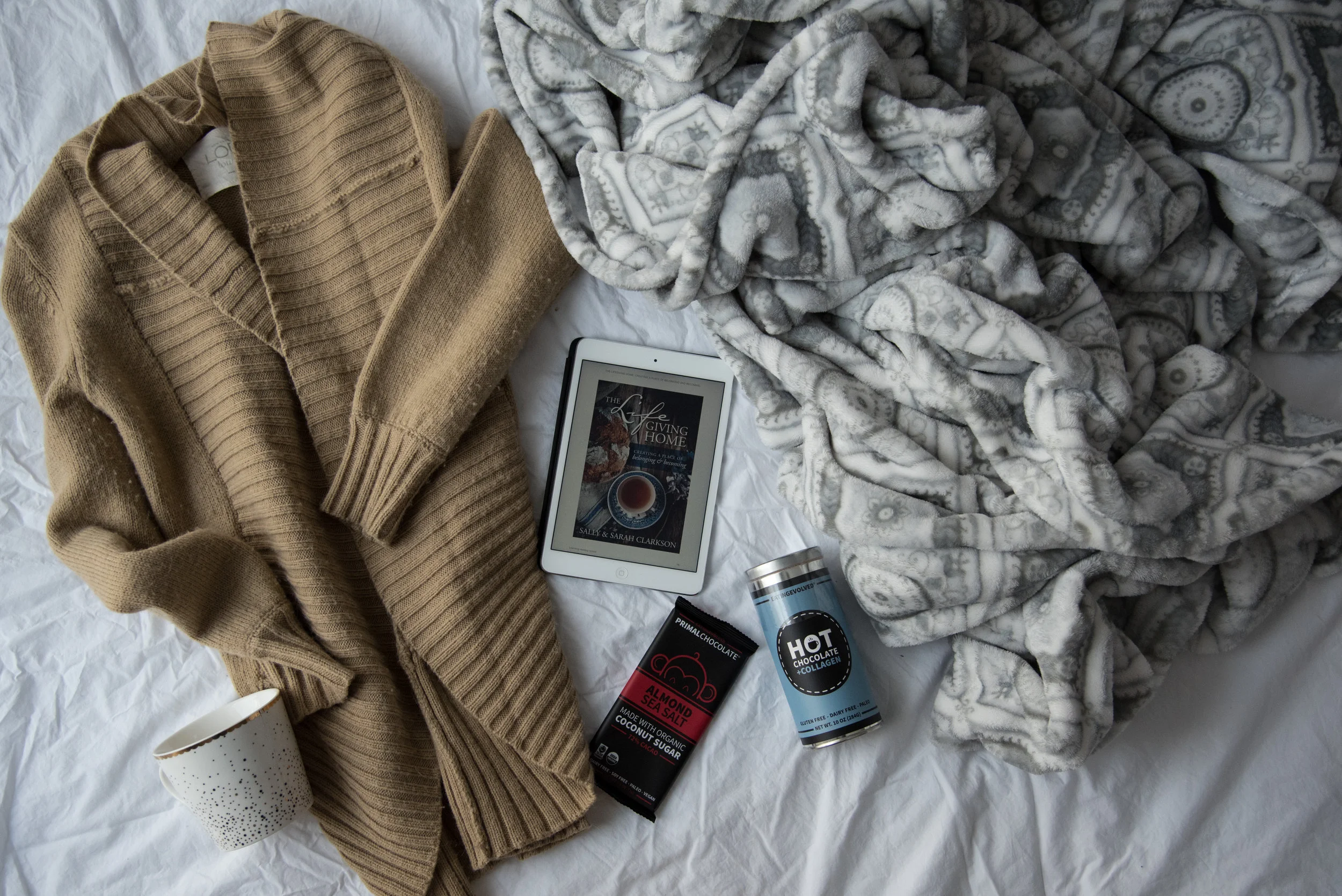 Hygge Faves: A cozy sweater, a pretty mug, yummy treats, a good read, and a snuggly blanket.
