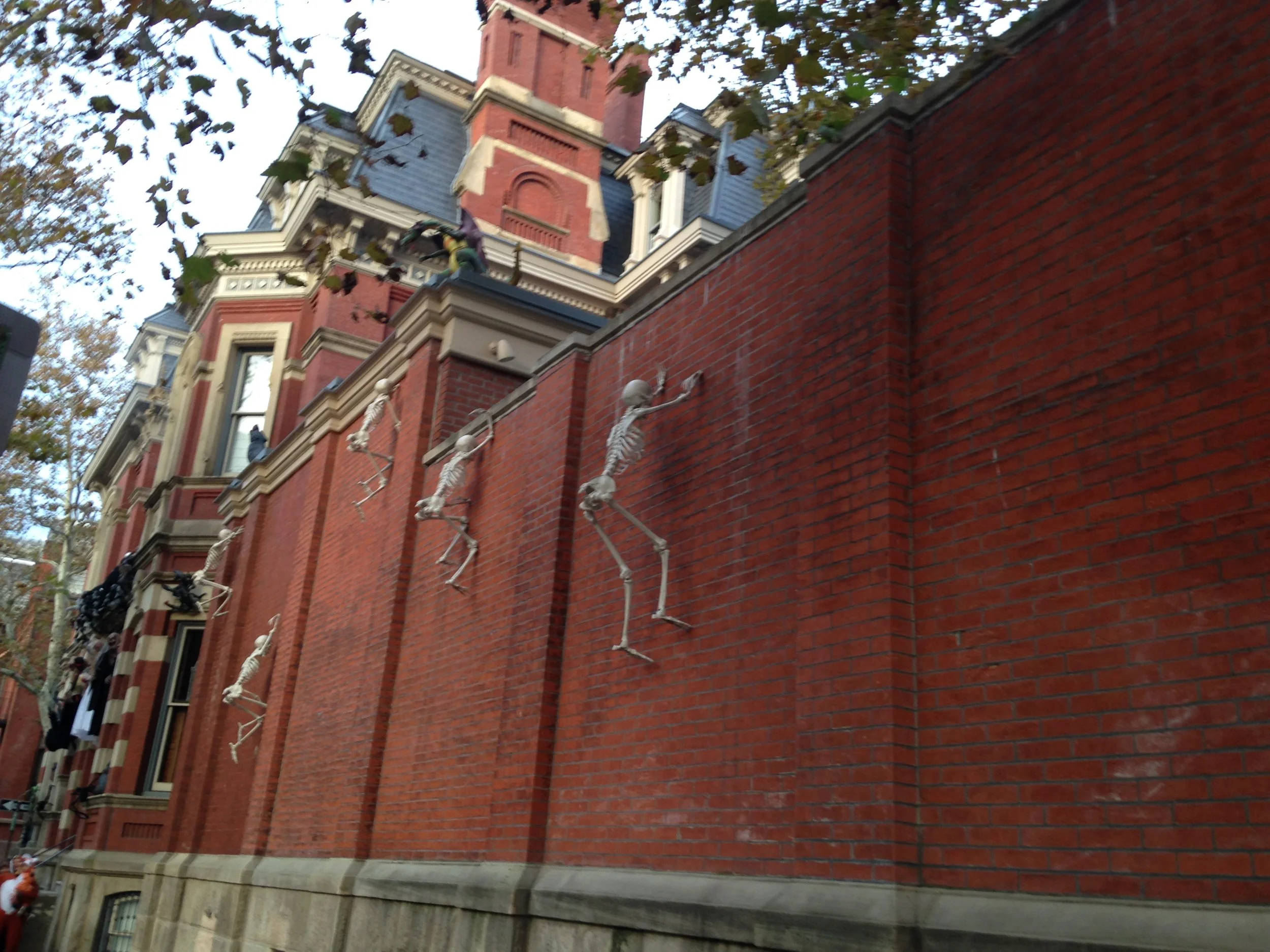 Skeletons scale the wall of this mansion