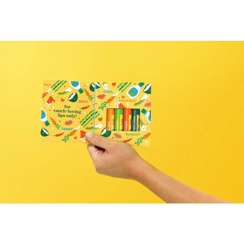 JPG High Res 800 Padded-bee-us-multiple-lip-balm-hidden-valley-ranch-with-balms-carton-yellow-background-shacora-surles_NI-61172.jpg