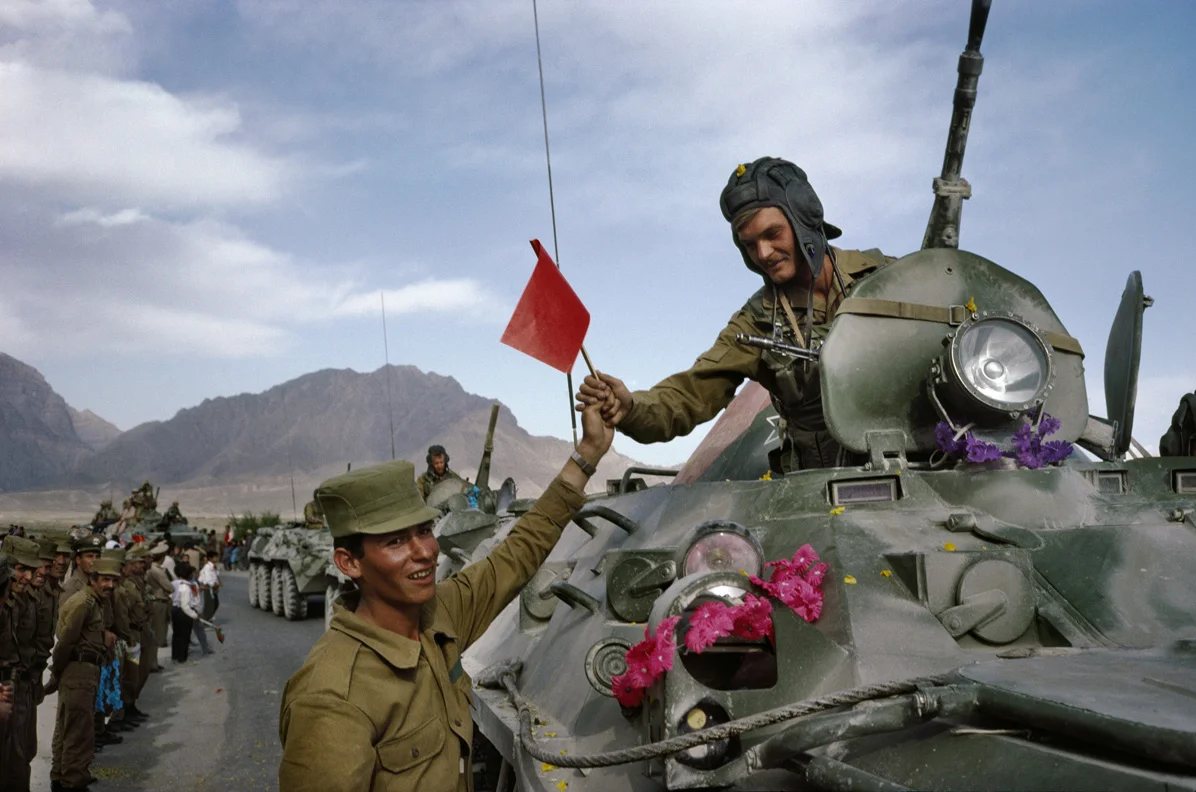 Afghan soldier hands red solidarity flag to Soviet officer, 2010