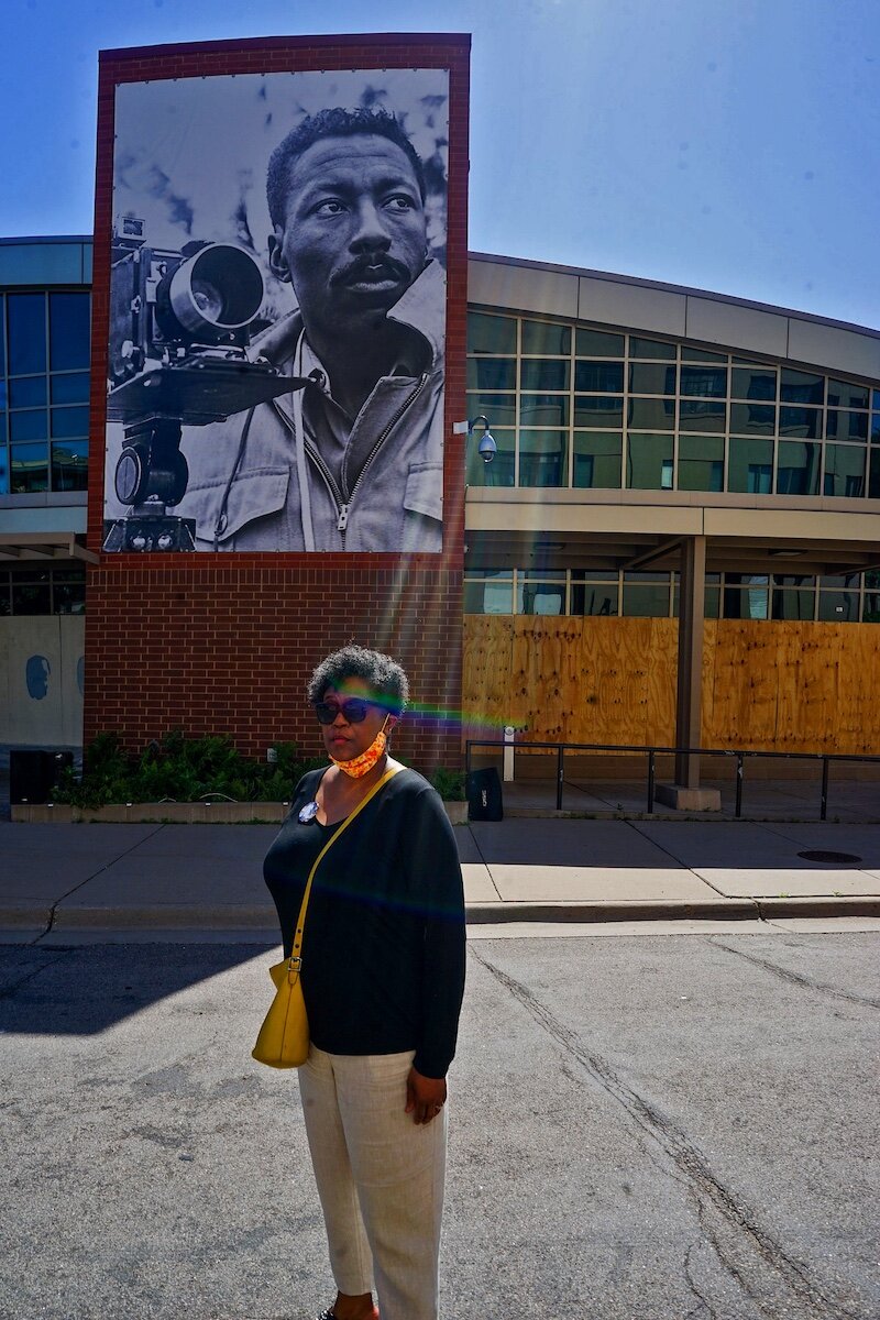  “June, 2020 - St. Paul, Minnesota - Robin Hickman, the niece of Gordon Parks, poses for a portrait in front the high school created in her uncle’s name. The high school, like many other black owned businesses and institutions, was set on fire during