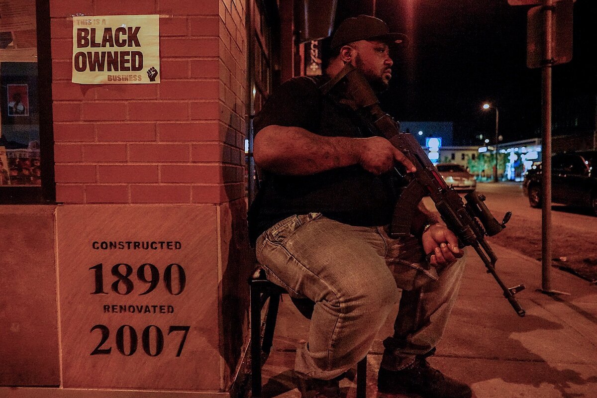  “June, 2020 - Northside Minnesota — Sippizone, a Marine veteran and record producer, stands guard by Sammy’s cafe. After a few days of protests, it became apparent that black &amp; latino-owned businesses and institutions were being targeted for des