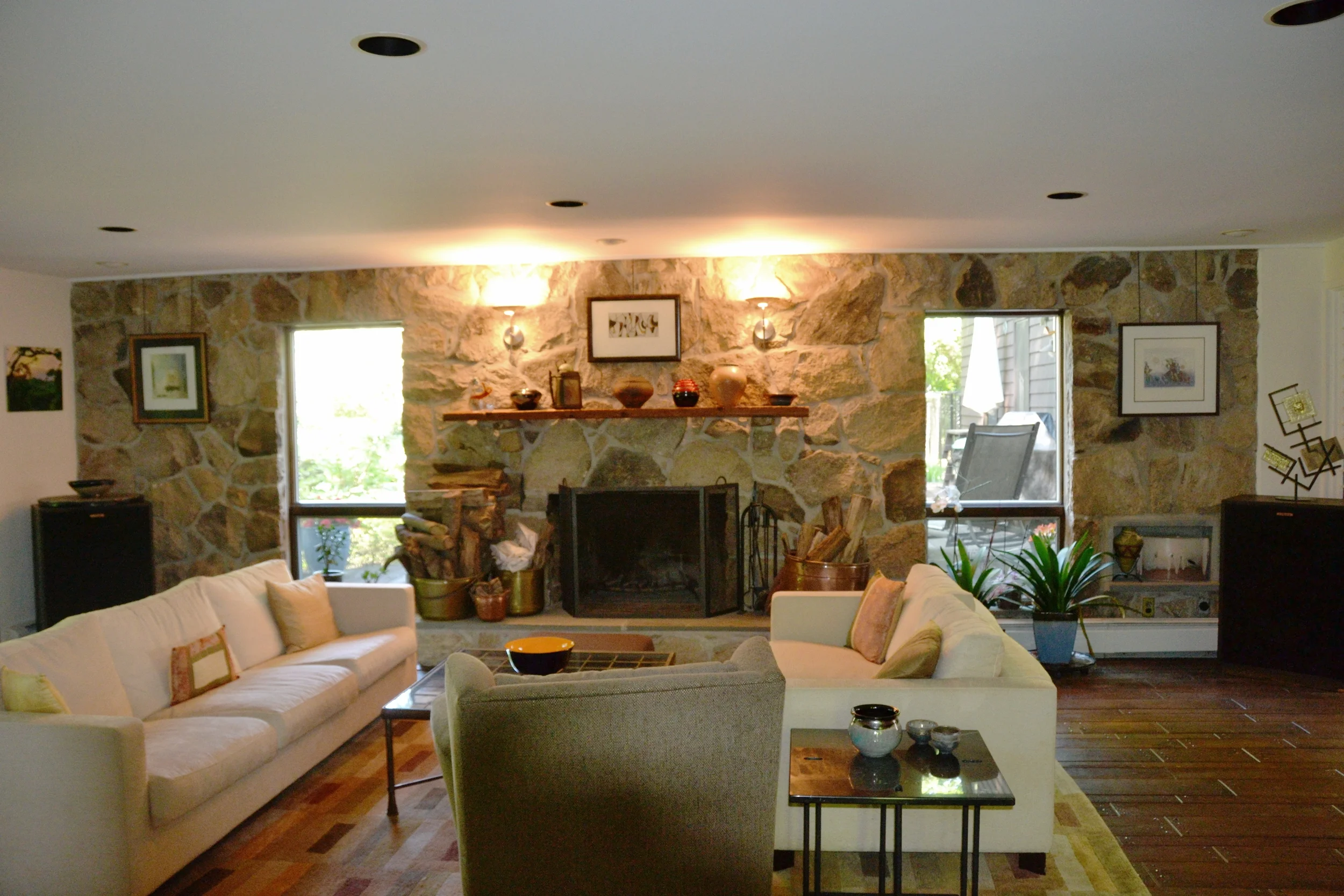LR - Fieldstone wall/fireplace w/sconces & Antique wood floor
