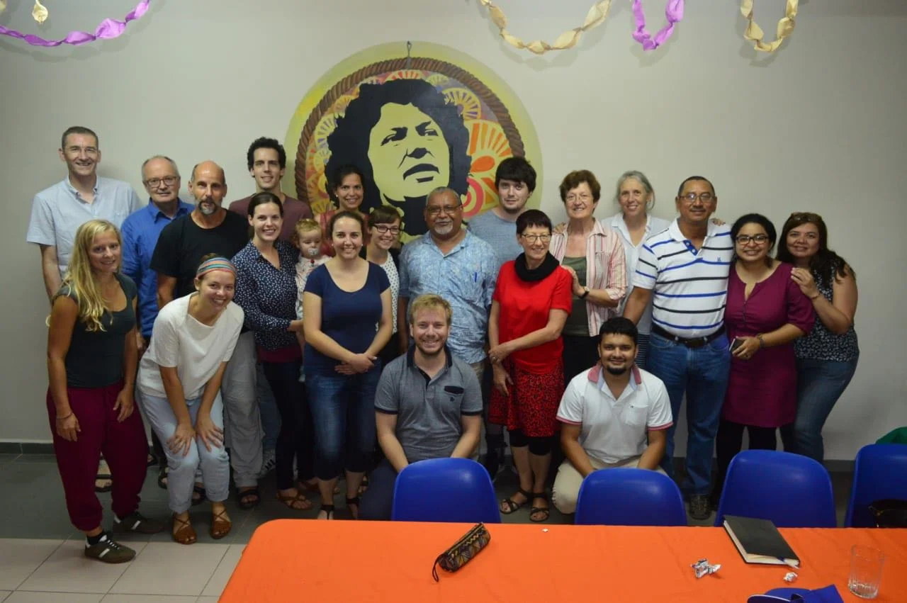 Unsere Reise-Gruppe auf Besuch bei einer jesuitischen Menschenrechts-Organisation. Das Bild and der Wand zeigt Berta Caceres - eine indigene Umweltaktivistin, die sich gegen die Landausbeutung internationaler Unternehmen einsetzte. Im März 2016 wurde Berta aufgrund ihres Engagements ermordet.