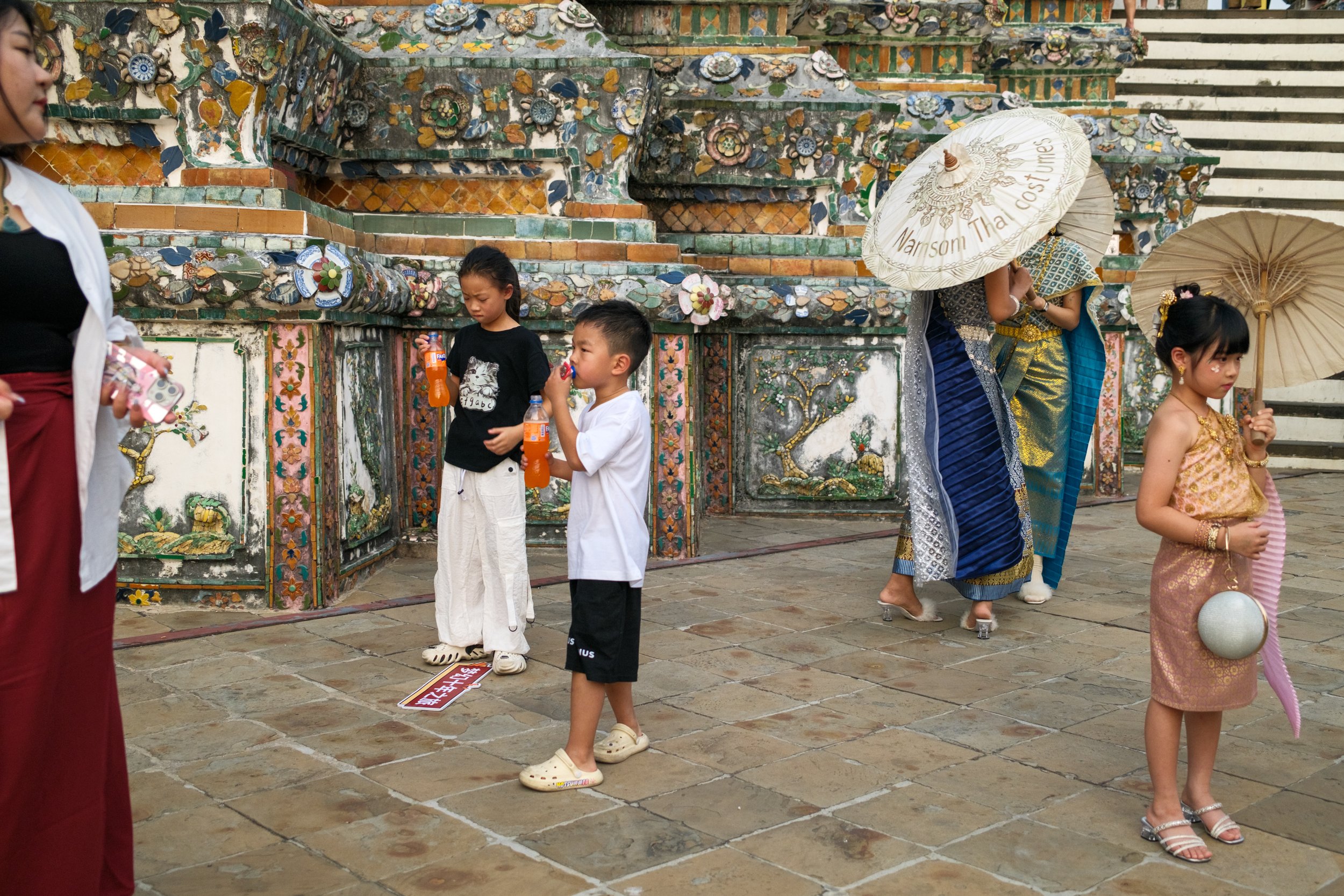 Wat Arun, the Temple of Dawn. There are many Thai traditional clothing rental shops nearby the temple, offering visitors the chance to wear the dresses and take pictures during their visit to the temple. Bangkok, Dec 2024.