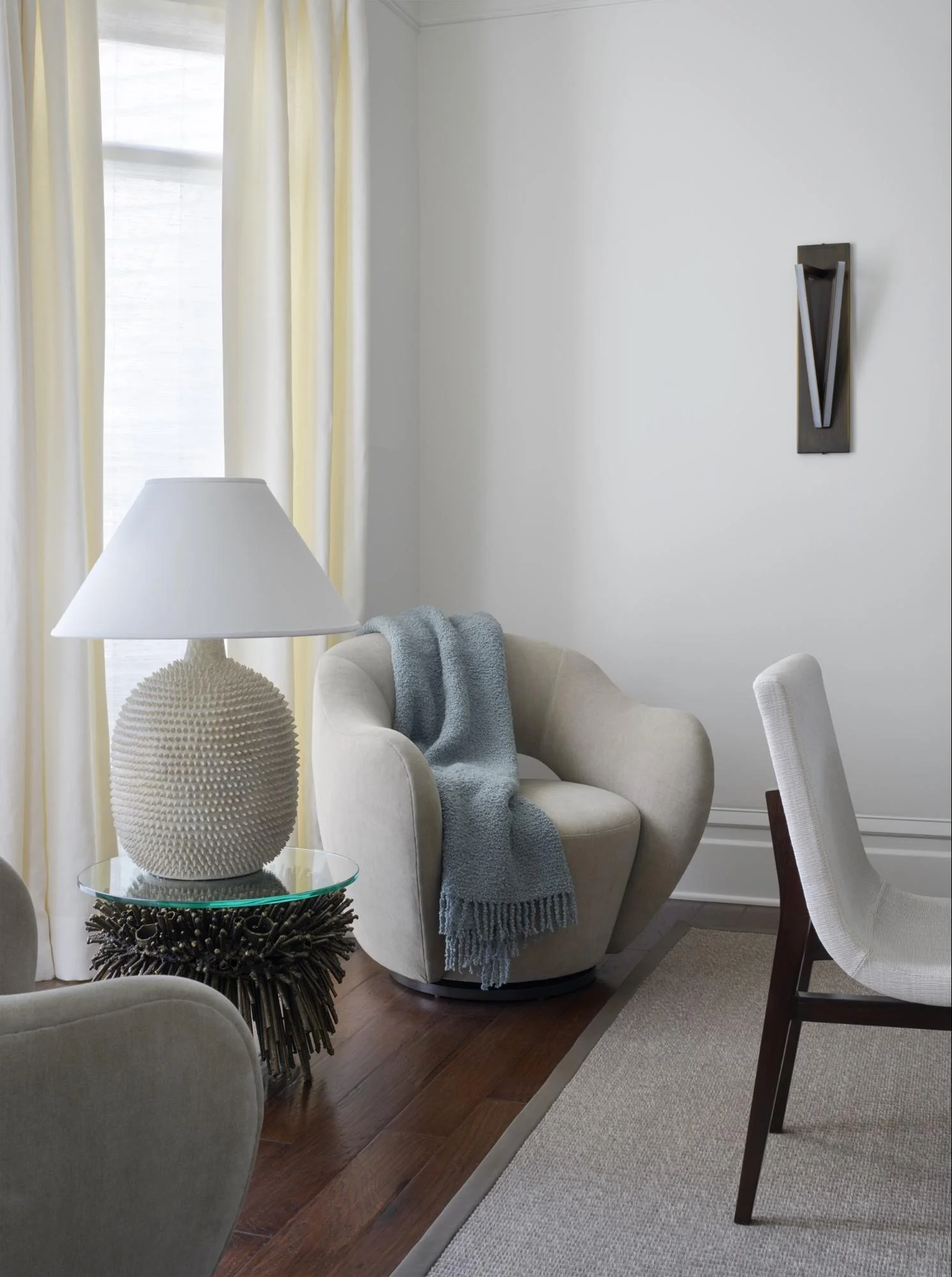 James Bearden's bronze Urchin Side Table centers the bay window of the dining room. It is flanked by a pair Vladimir Kagan's contour low back Wysiwyg lounge Chair.