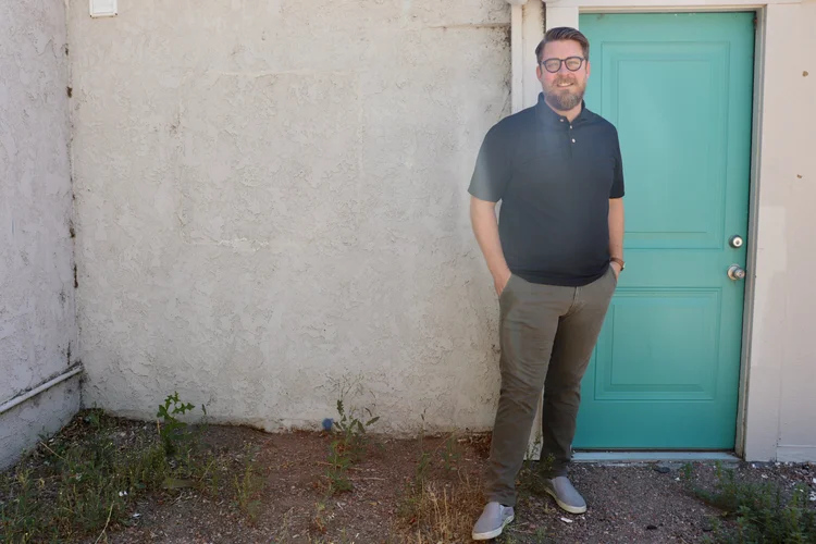 Scott Treas standing beside a teal door