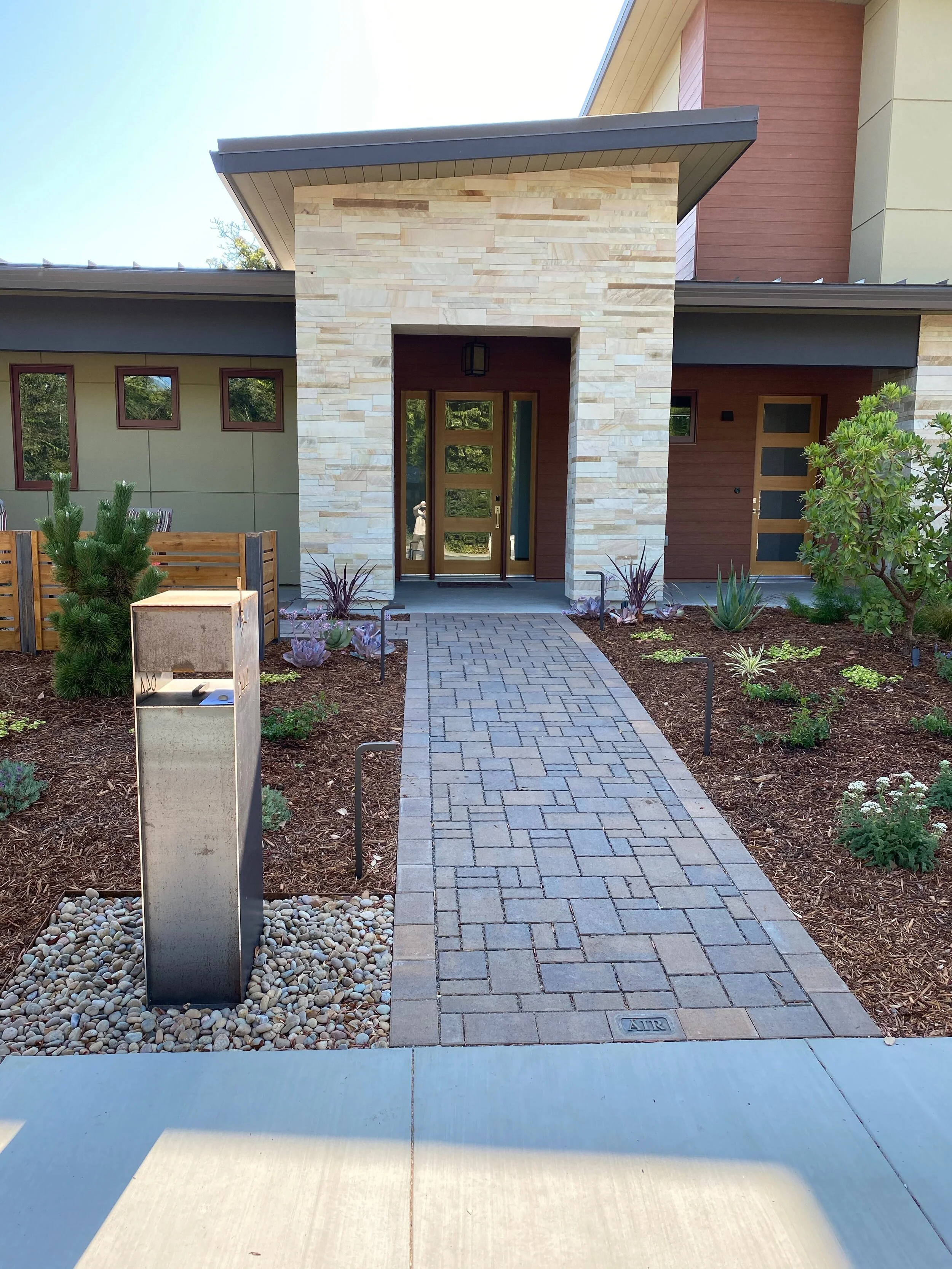  Permeable paver pathways and patios, surrounded by new plantings and a corten steel mailbox.  