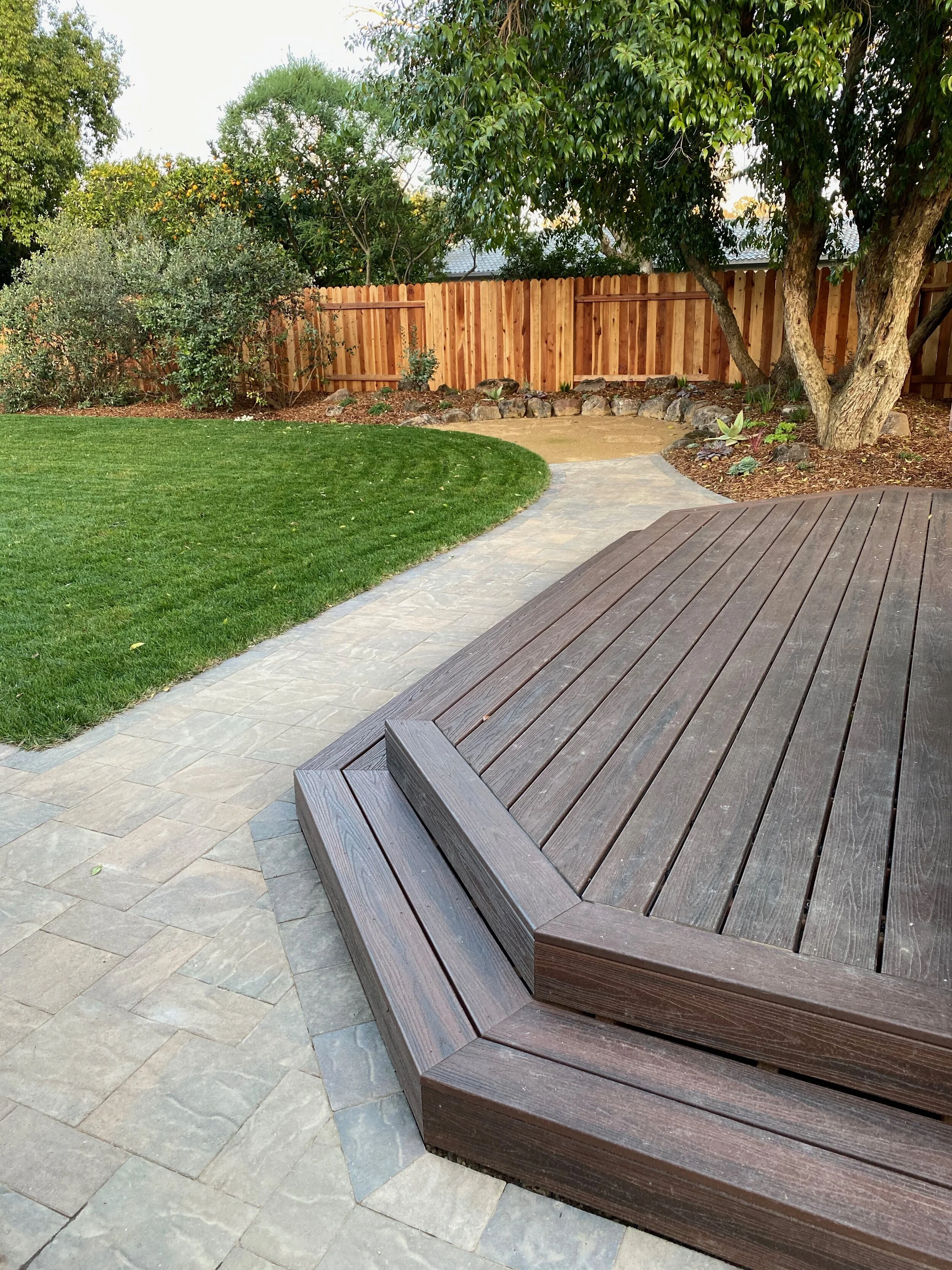 New deck, pavers, lawn and decomposed granite patio surrounded by moss rock. 