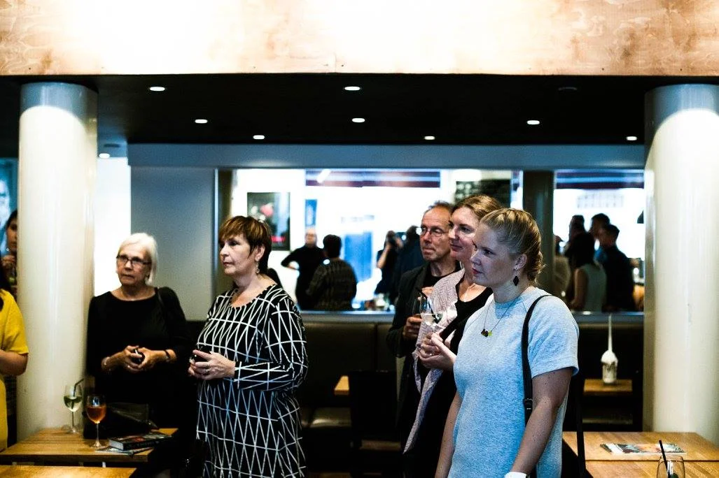 Här lyssnar vi andäktigt på Marias tal på releasefesten. Jag i grå klänning.