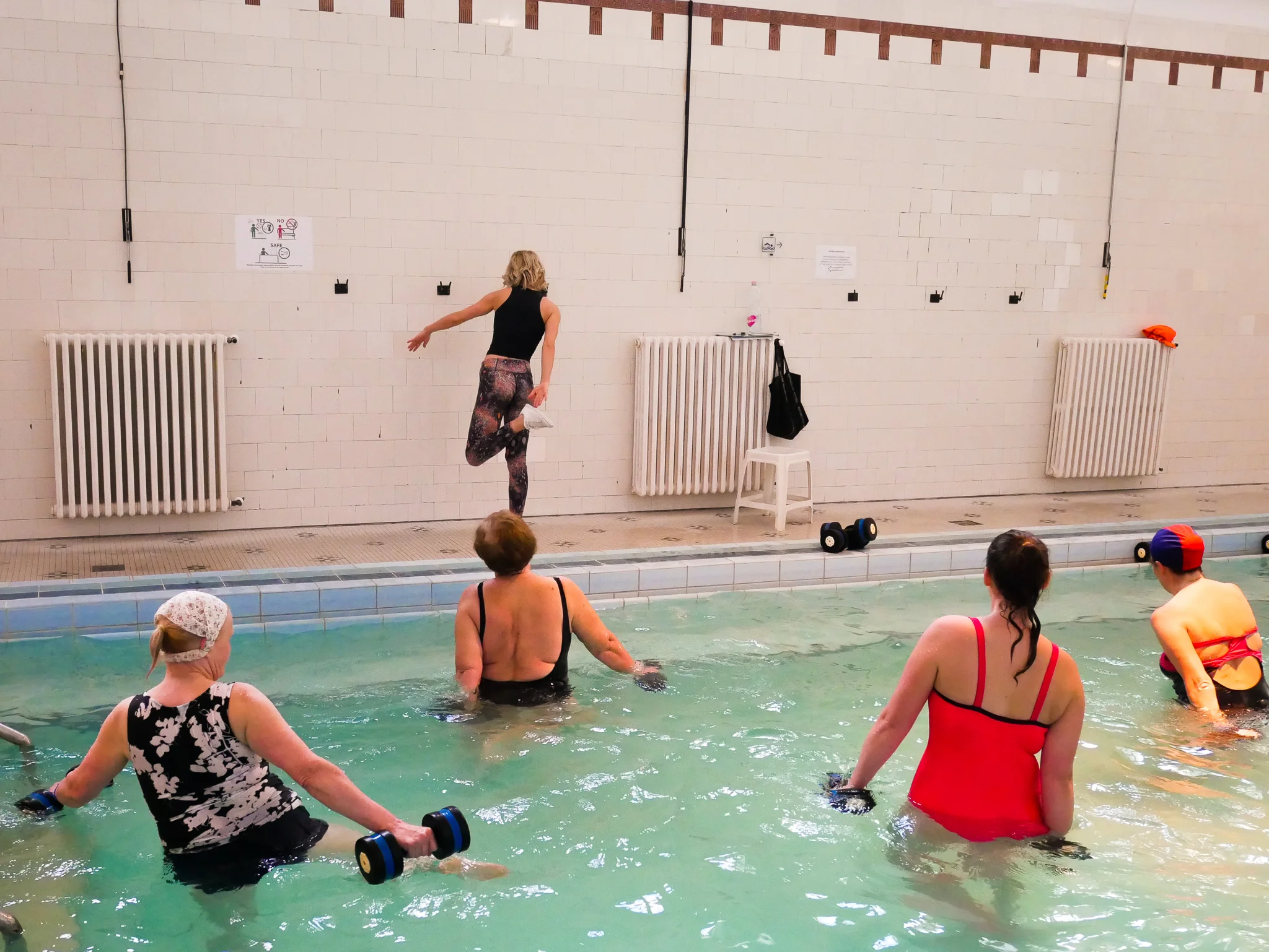 Här pågår den märkligaste vattengymnastiken jag beskådat. Instruktören såg inte det minsta intresserad ut av vad hon gjorde. Men alla i poolen verkade nöjda och glada.