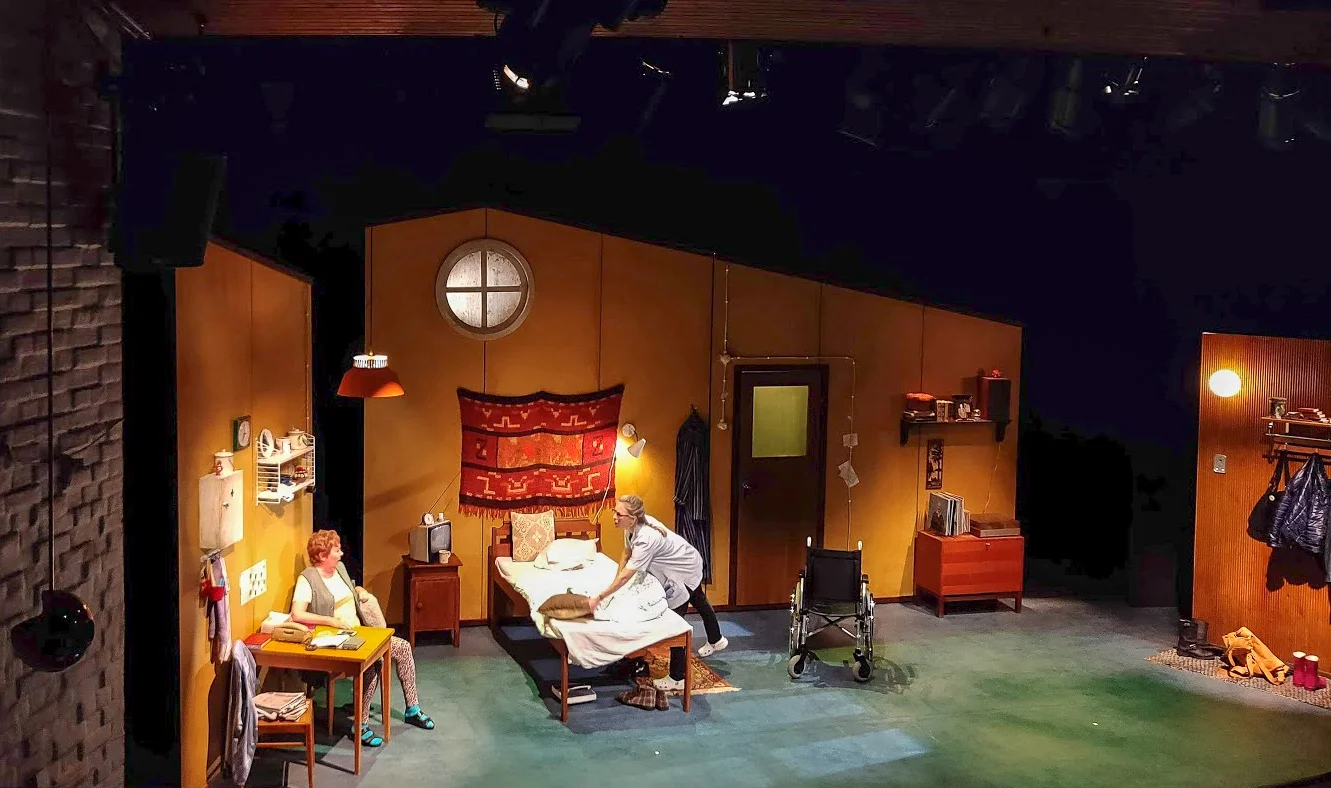 Scenografin och kläderna känns också helrätt! Panterbyxor, crocs och träpanel.