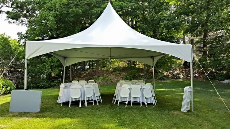 20x20 white high-peak tent with round tables and white chairs on a lawn