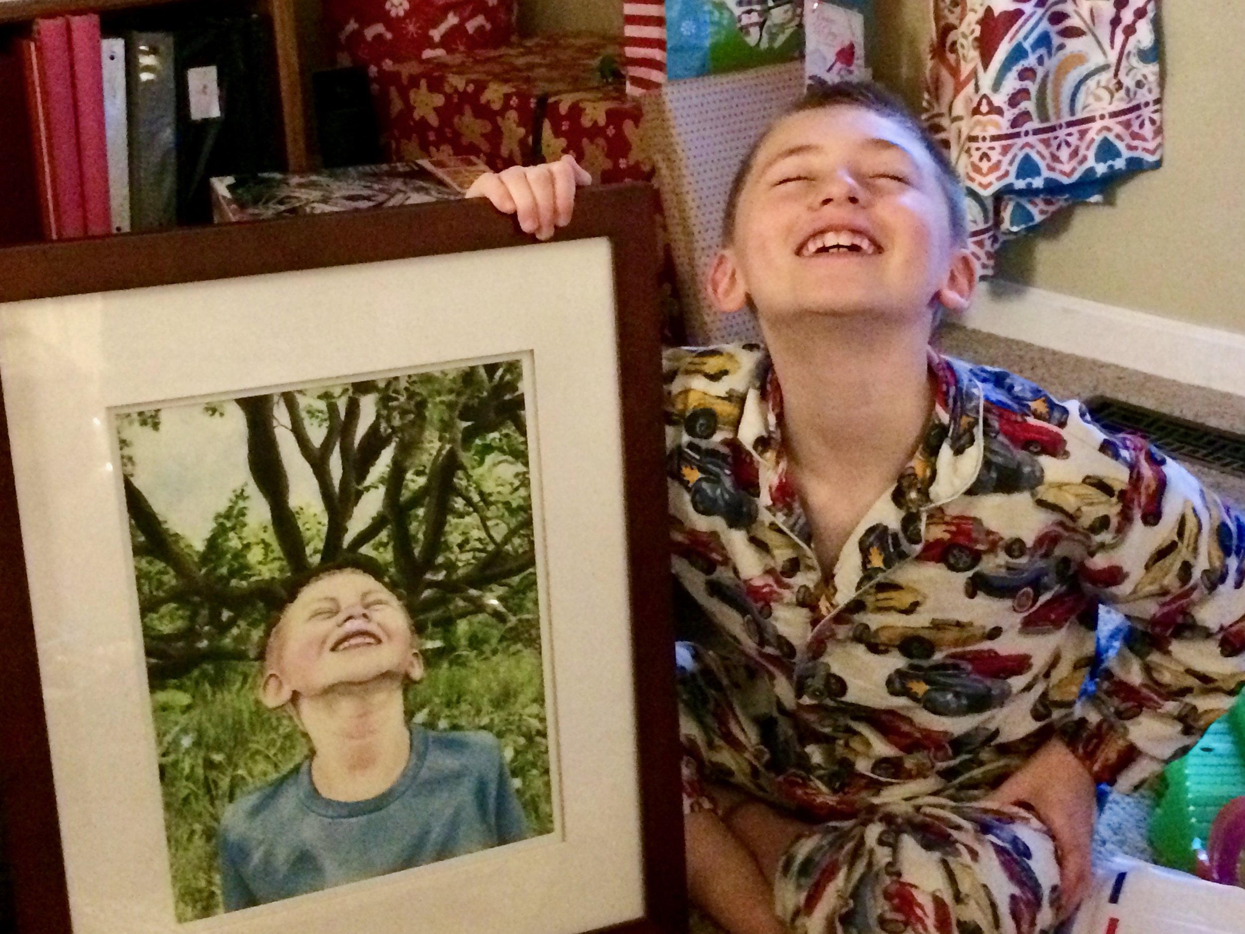 My nephew posing on Christmas morning with the portrait of him I painted