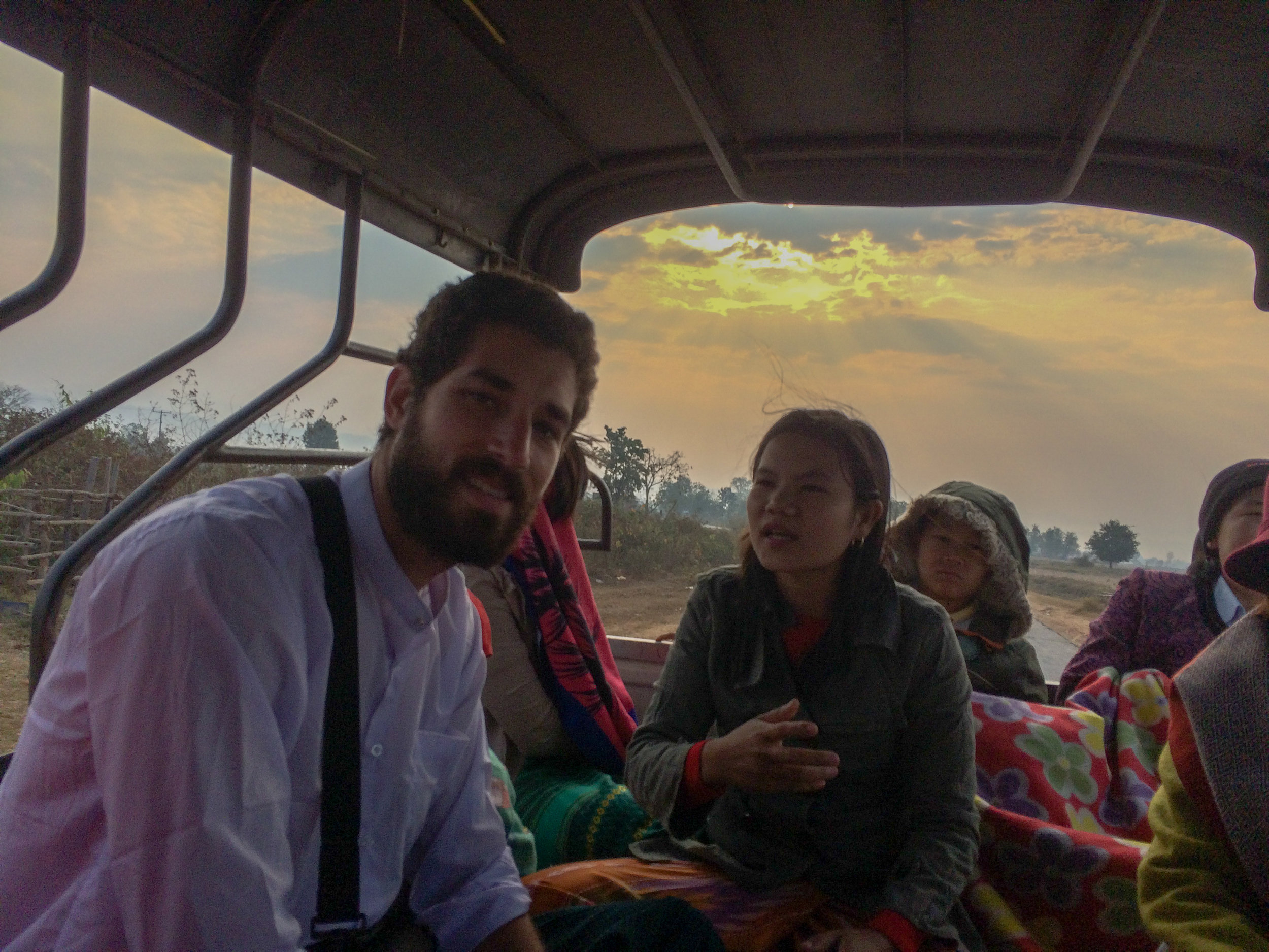 Riding in the back of a pick-up with a family in Myanmar for a two hour ride along unpaved roads.