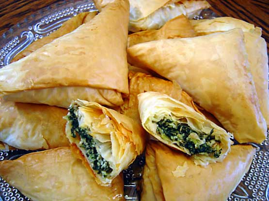 Spanakopita a delicious pastry with a filling of chopped spinach, feta cheese, onions or scallions, egg, and seasoning.The filling is wrapped or layered in phyllo (filo) pastry with butter