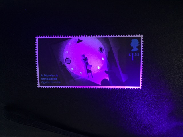 Exposure to UV light reveals the clock face on the 'A Murder is Announced' stamp