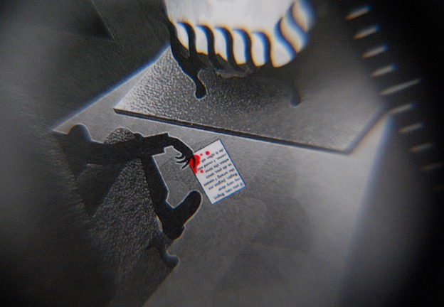 Looking through a magnifying glass reveals the detail of the suicide note on 'The Murder of Roger Ackroyd' stamp