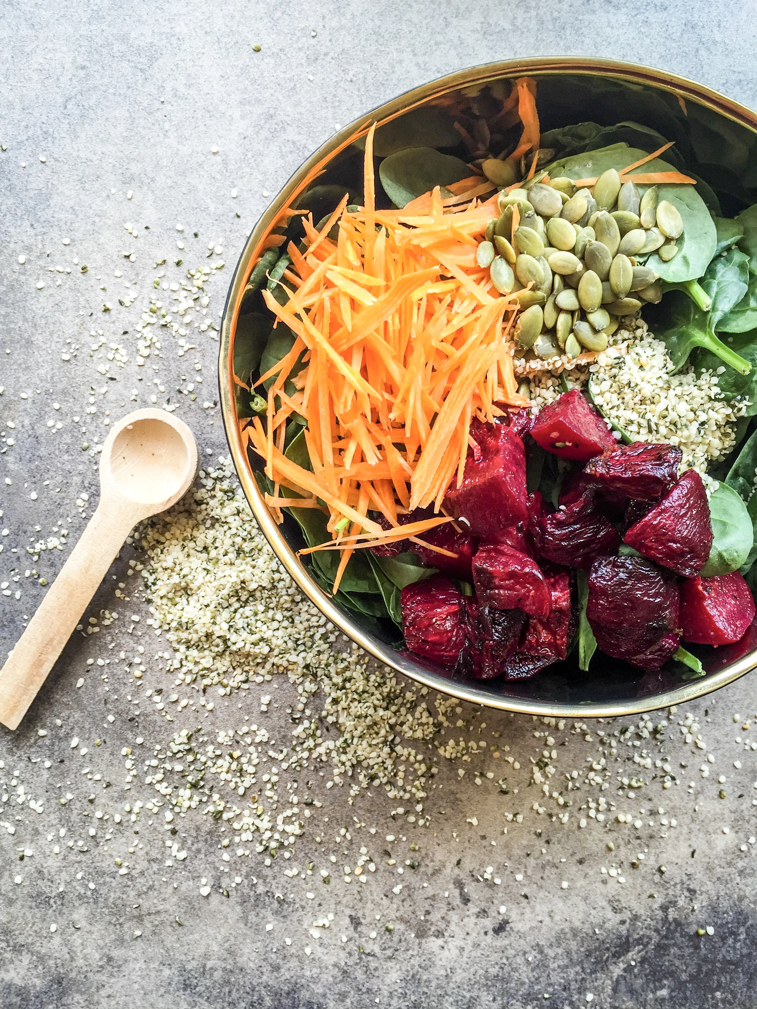 Roasted beet salad with spinach, hemp seeds, pepitas, and carrots.