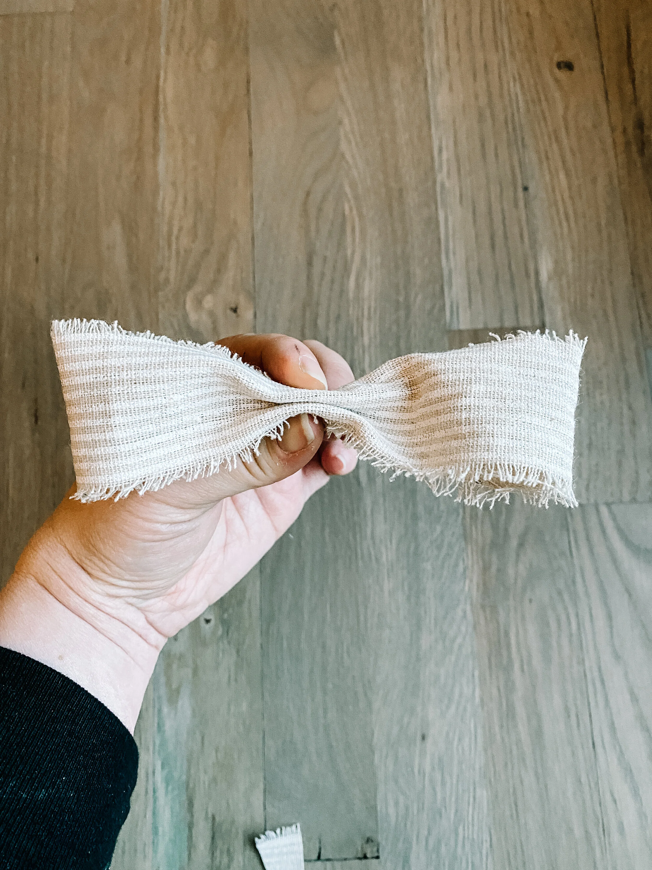  Pinch the center of your two loops to create the sides of the bow. 