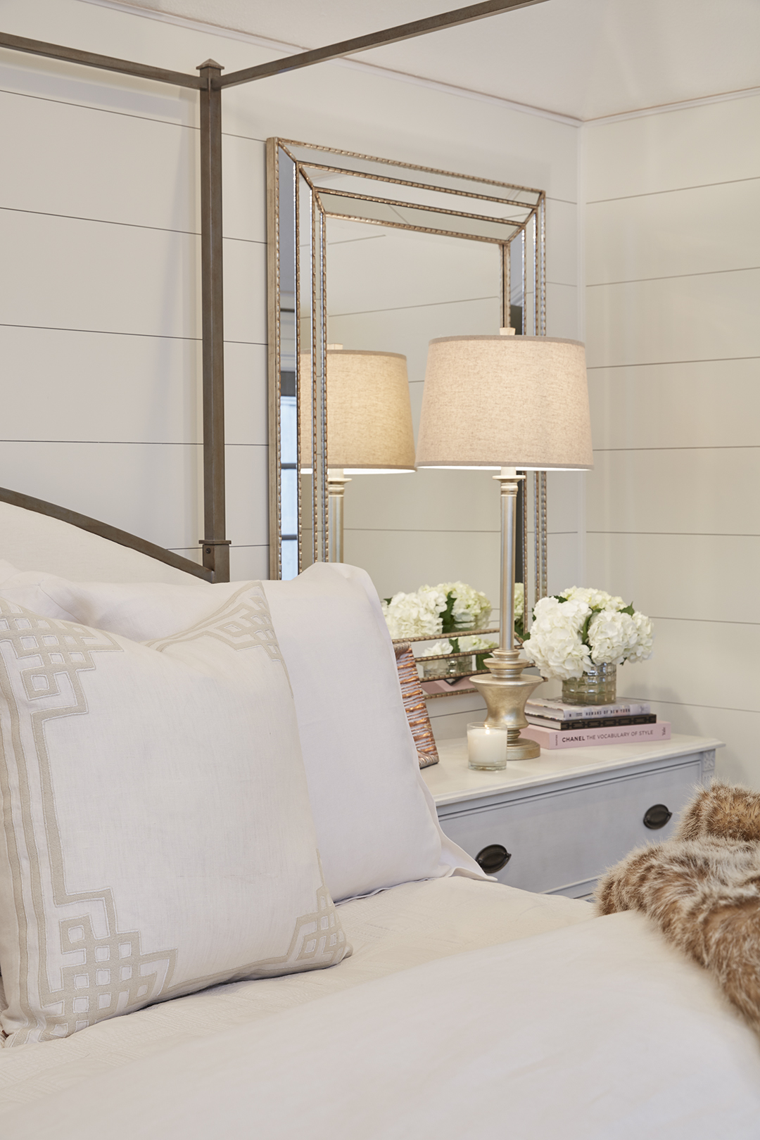 The shiplap continues into the master bedroom. Like the master bathroom, it offers a chic, glamorous take on farmhouse styling.