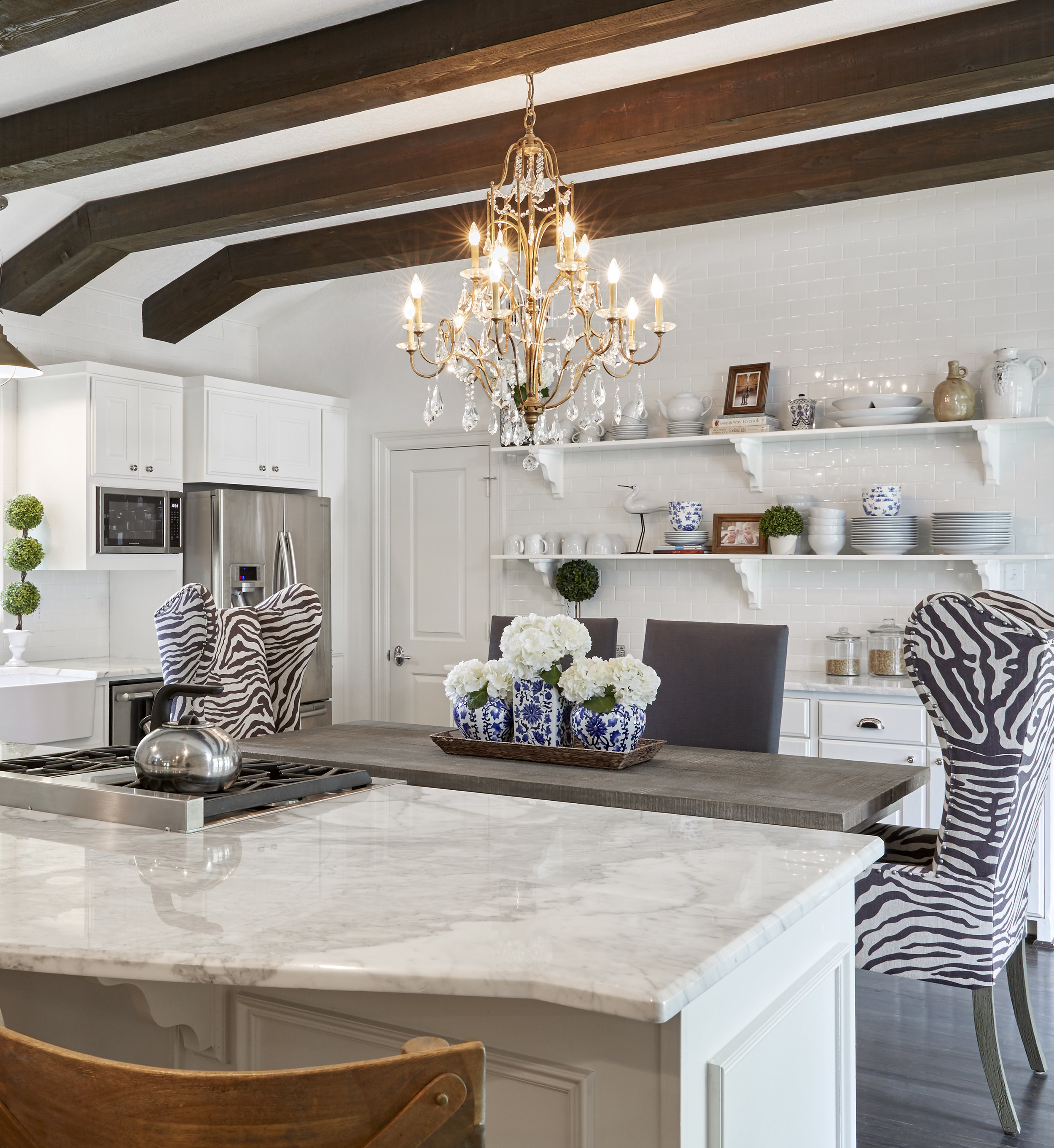 A freestanding island once sat where designer Emily Hewett and her family now enjoy meals. When the previous owners took it with them, Emily decided to hang a chandelier and, in true farmhouse fashion, embrace an eat-in concept. She then lowered the existing serving bar to suit barstools and 3-year-old twins Beckham and Stella, topping the new family friendly island with Calacatta Borghini marble.