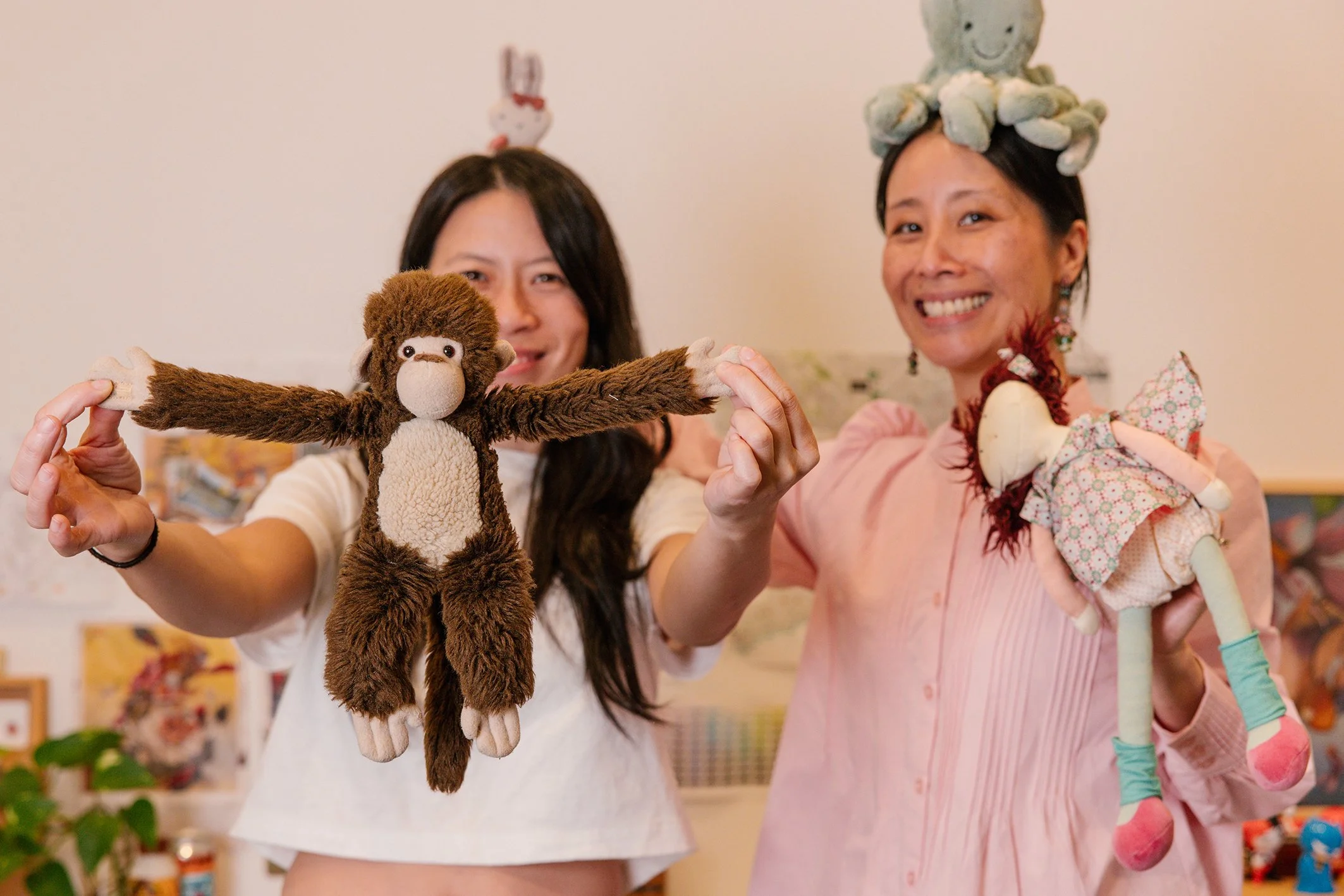 Christina Huynh and Madame Ng hold up plush toys for Finders Keepers the Book in studio