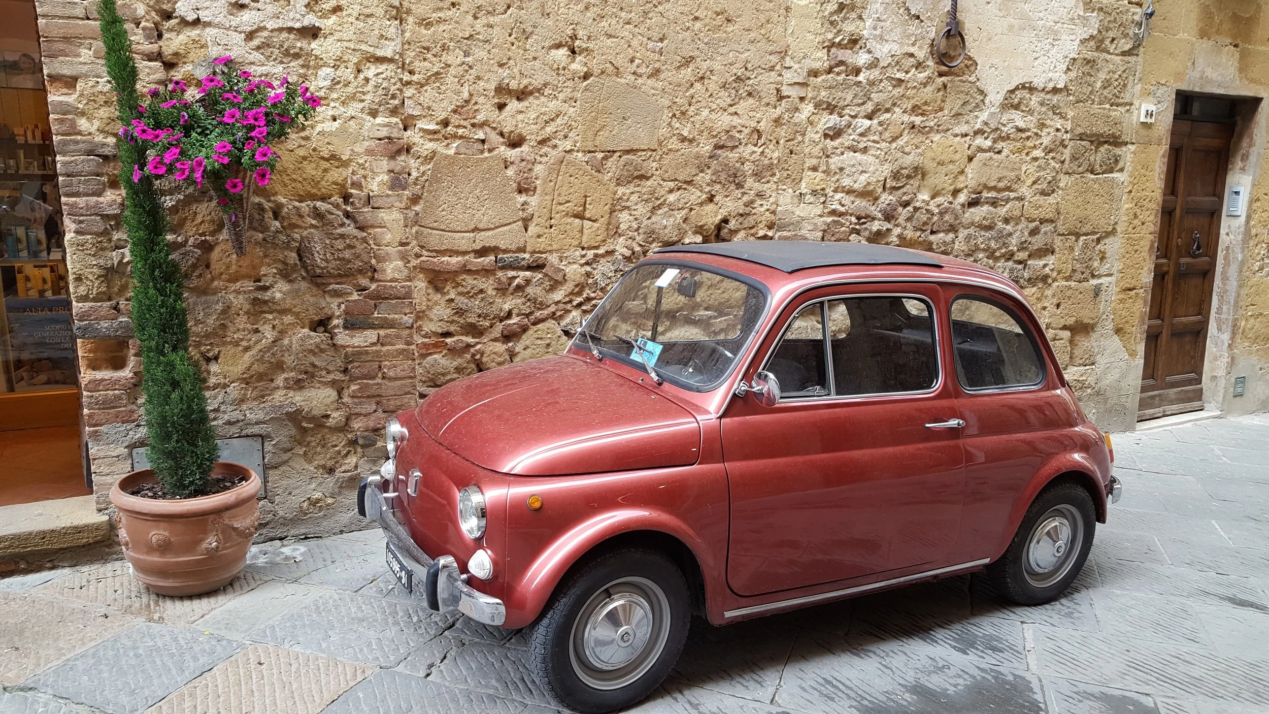 A vintage Fiat 500 parked in Pienza